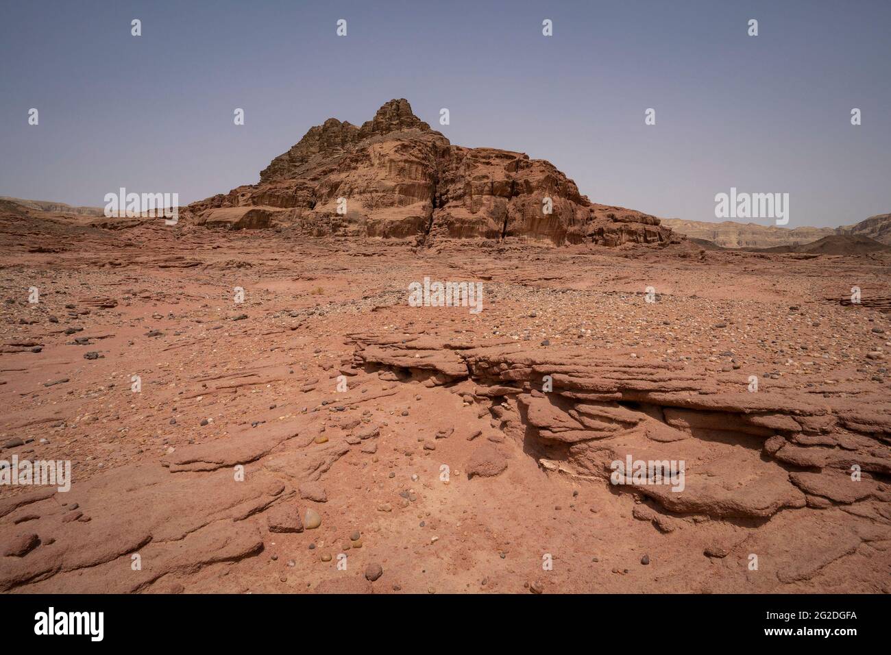 A desert landscape with red sand and red rock formations, in the Timna valley park in southern Israel. Stock Photo