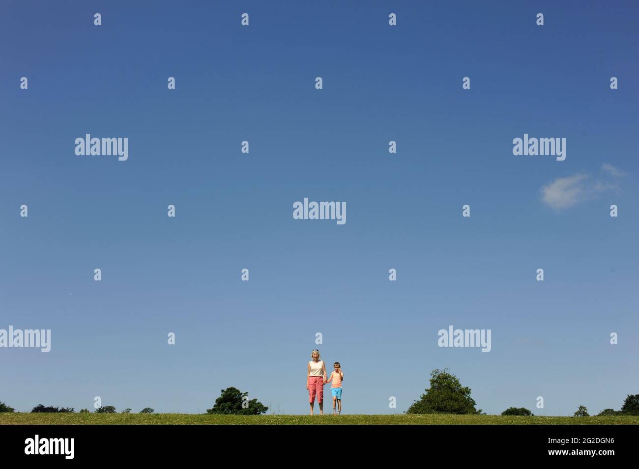 A grandmother and grandkid standing on the horizon in summer Stock Photo
