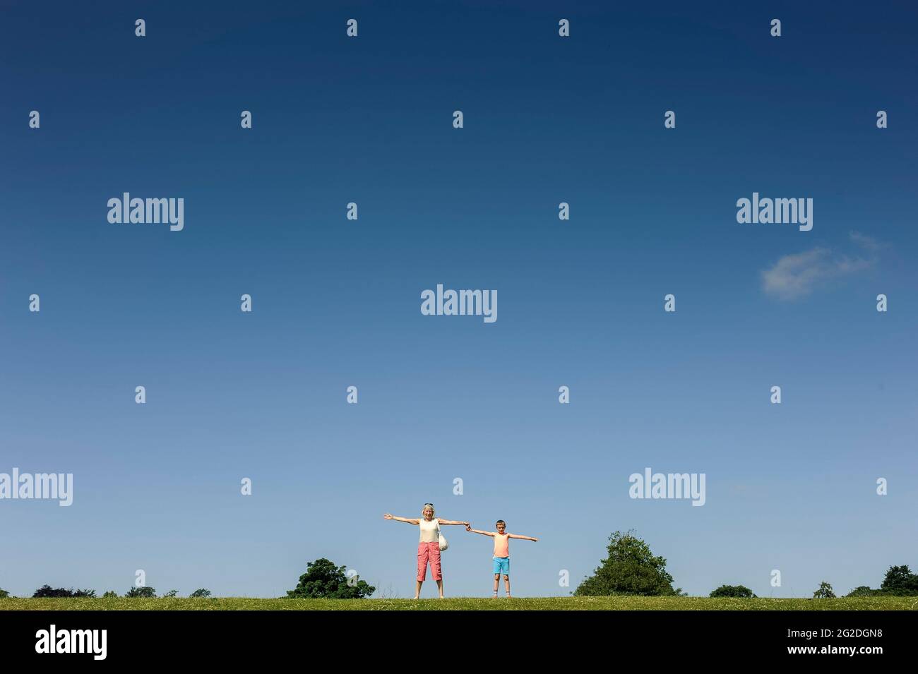 A grandmother and grandkid standing on the horizon in summer Stock Photo