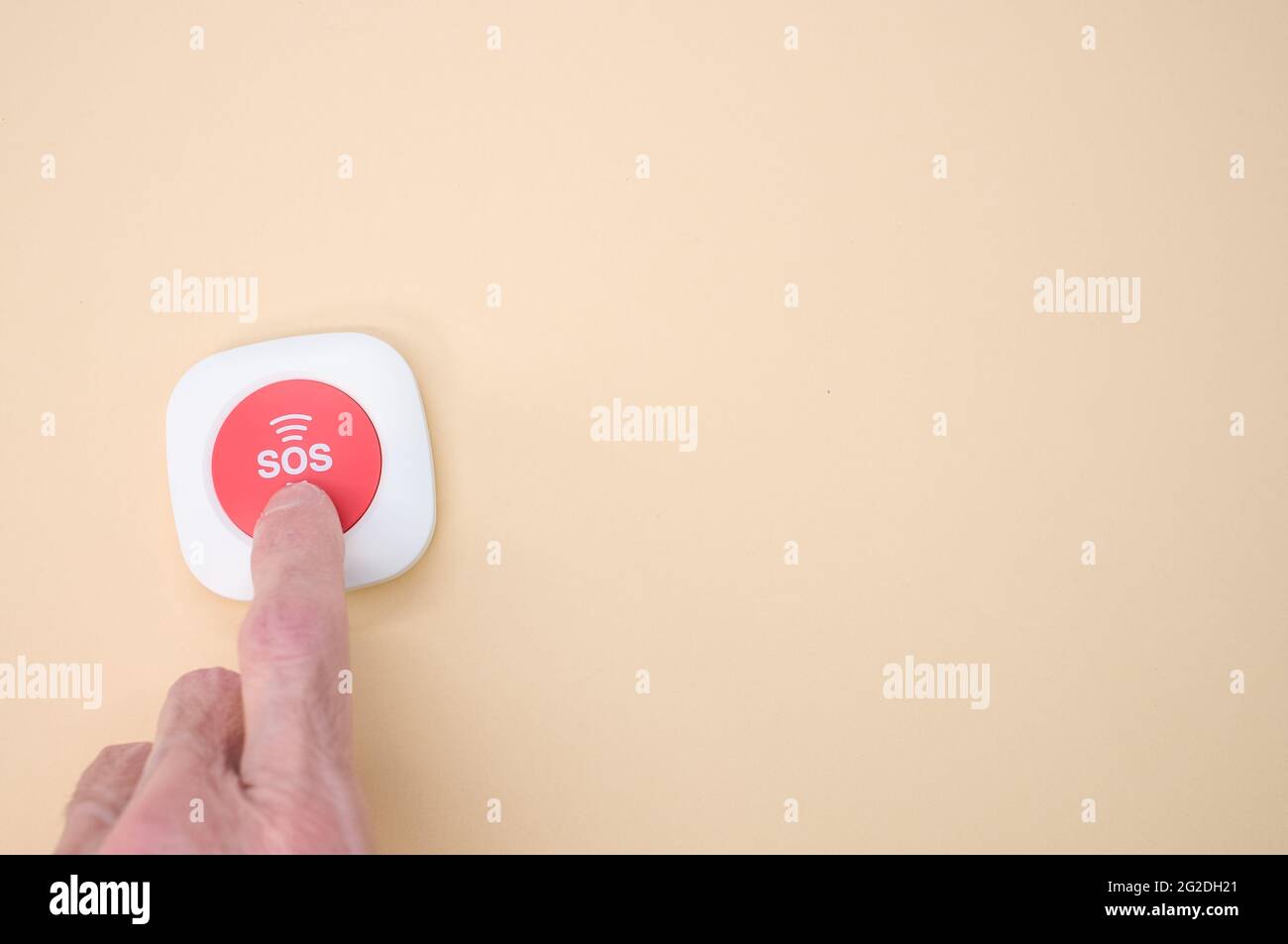 Elderly hand holding a wireless SOS emergency alarm button isolated on ...