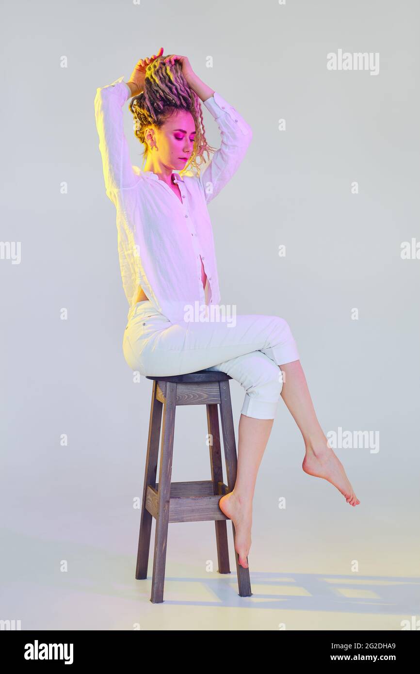 Full length portrait of young tender woman in white clothes lifting ...