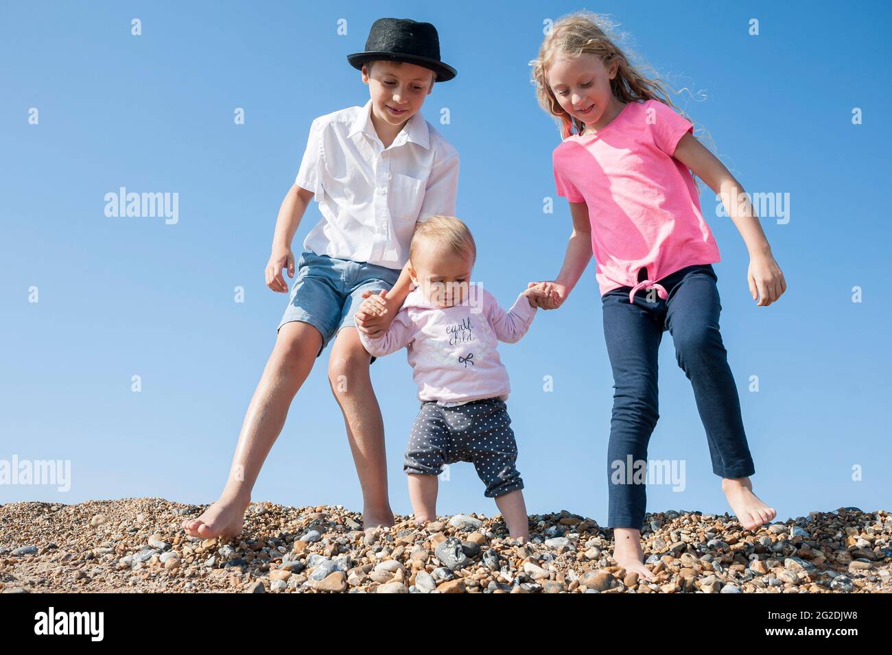 A young kid experiences the great british sea side on a beach in Shoreham-by-Sea Stock Photo