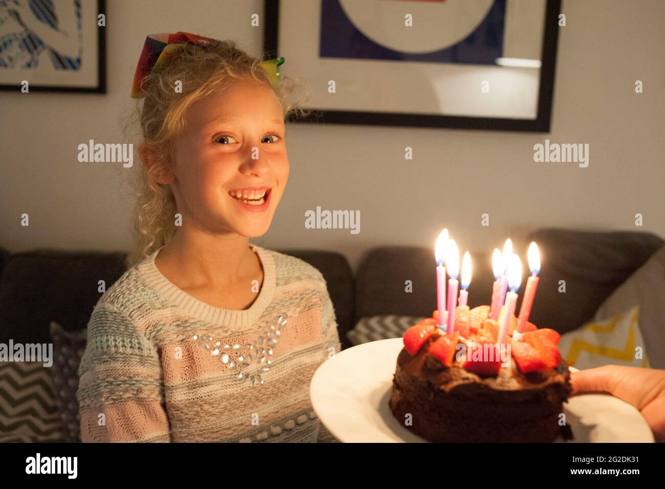 A Mother Holds Out A Birthday Cake For A Little Girl On Her 7th A Mother Holds Out A Birthday Cake For A Little Girl On Her 7th