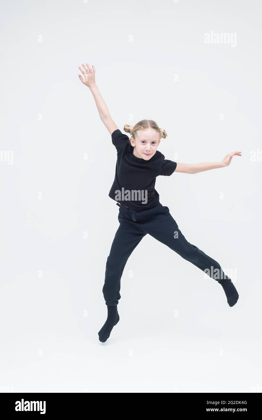A child stands on a white seamless background wearing all black clothes Stock Photo