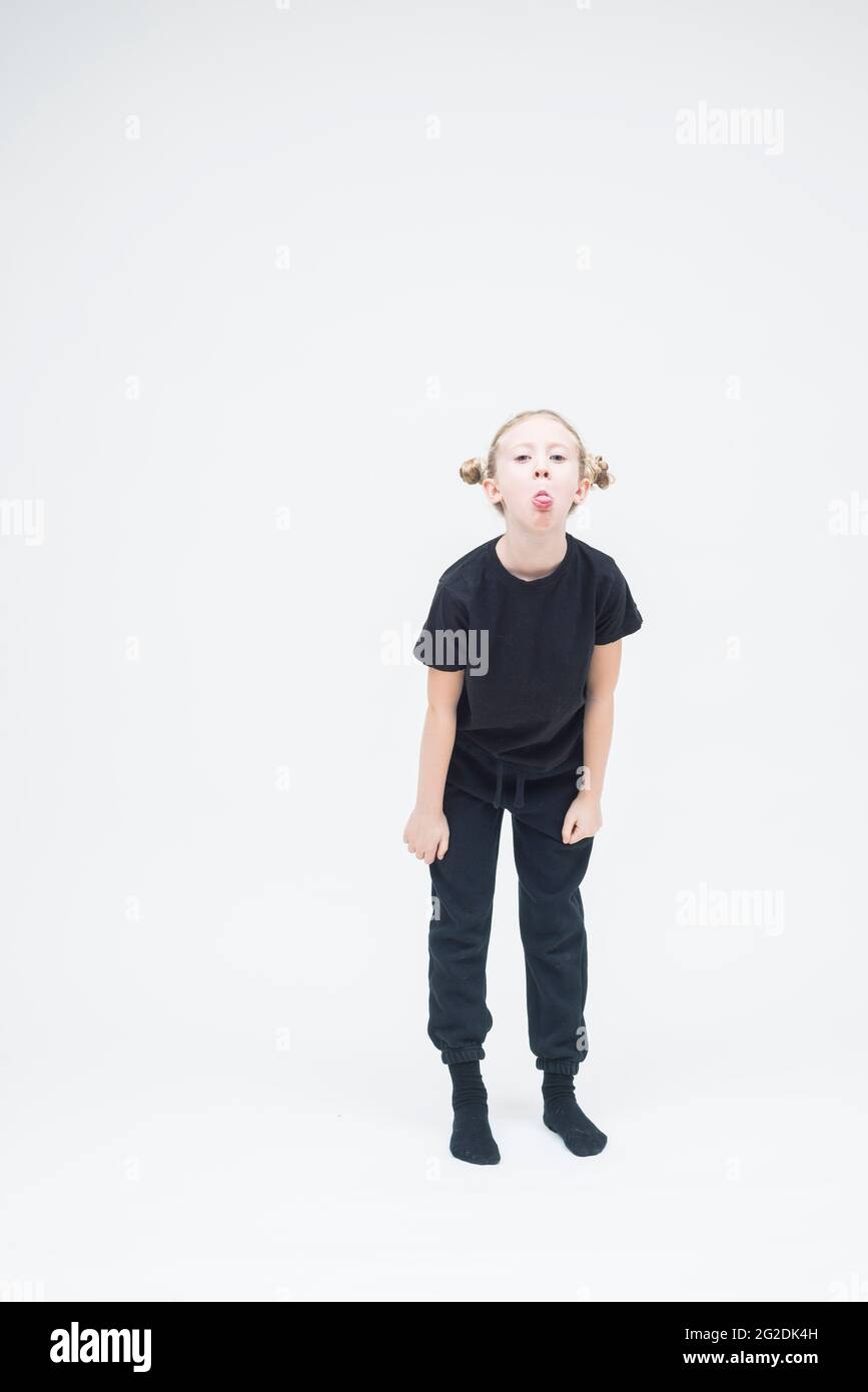 A child stands on a white seamless background wearing all black clothes Stock Photo