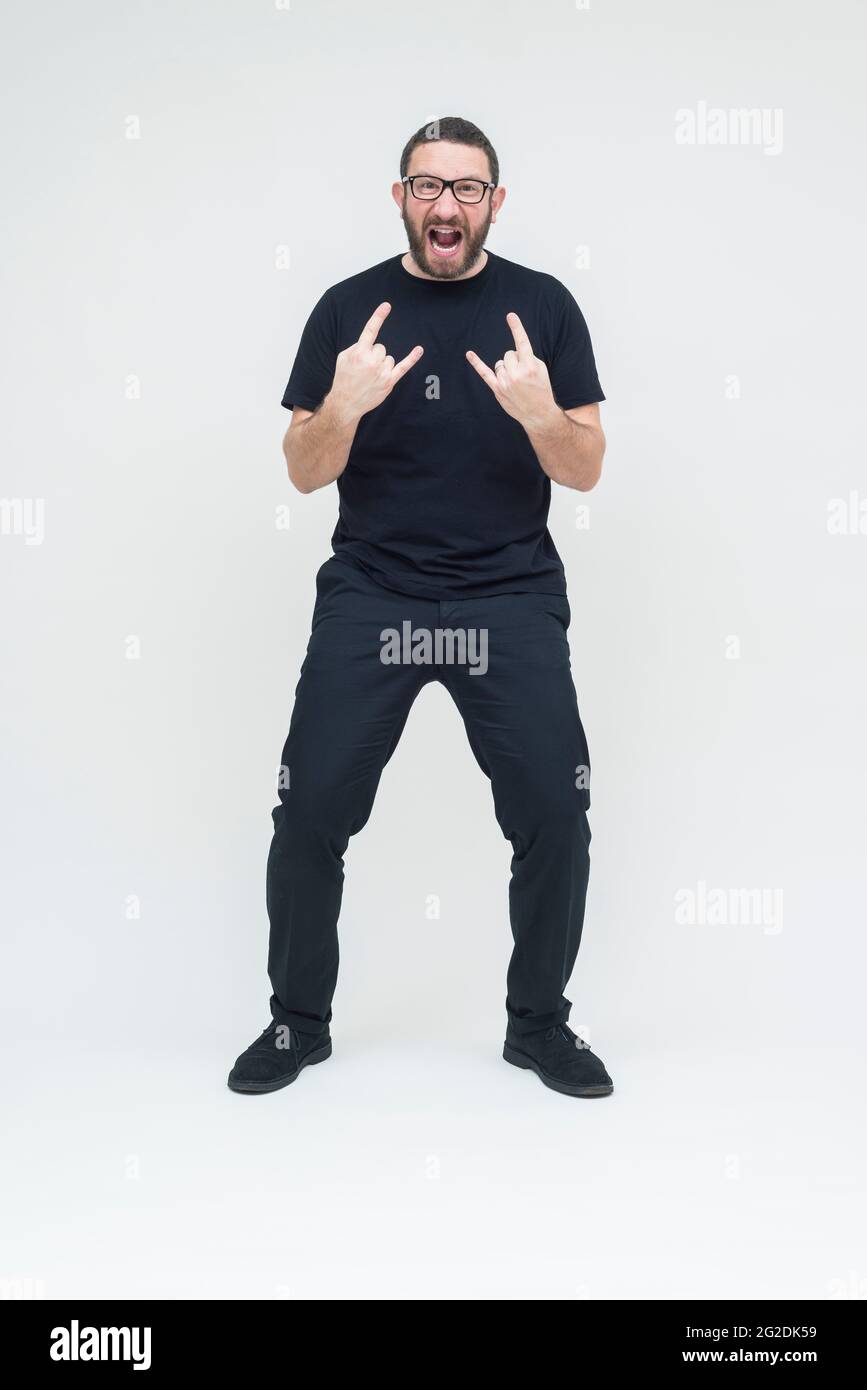 A man dressed in all black stands on a seamless white background in a photography studio Stock Photo
