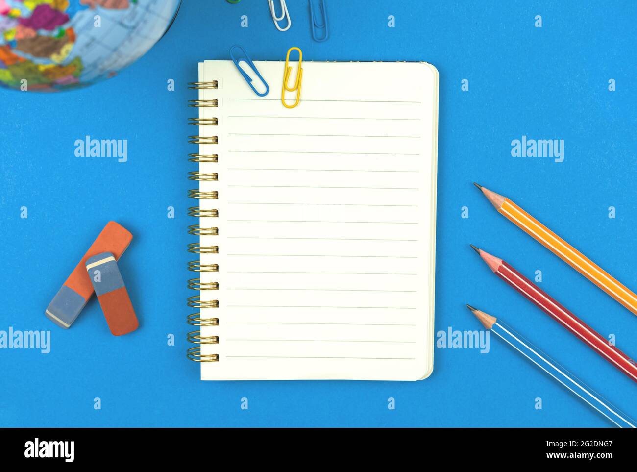 Blank lined notebook mockup with school stationery, pencils on blue background, flat lay composition top view photo Stock Photo
