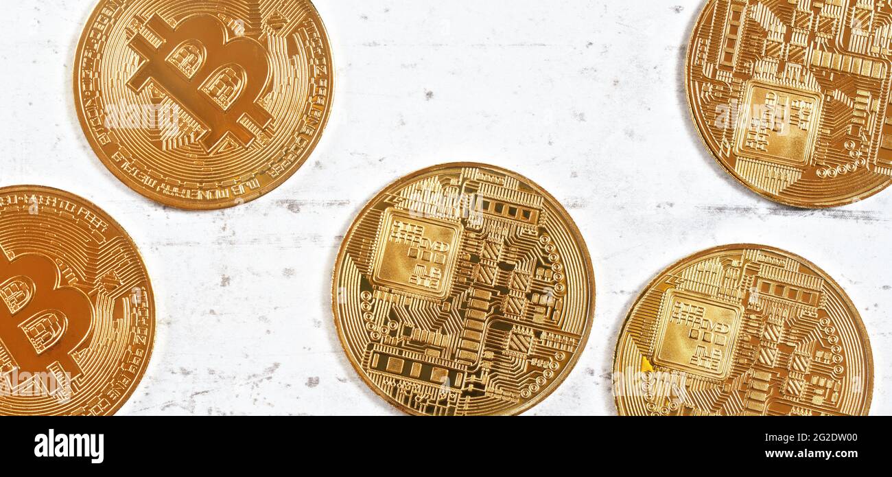 Golden commemorative btc - bitcoin cryptocurrency - coins scattered on white stone board, closeup detail from above Stock Photo