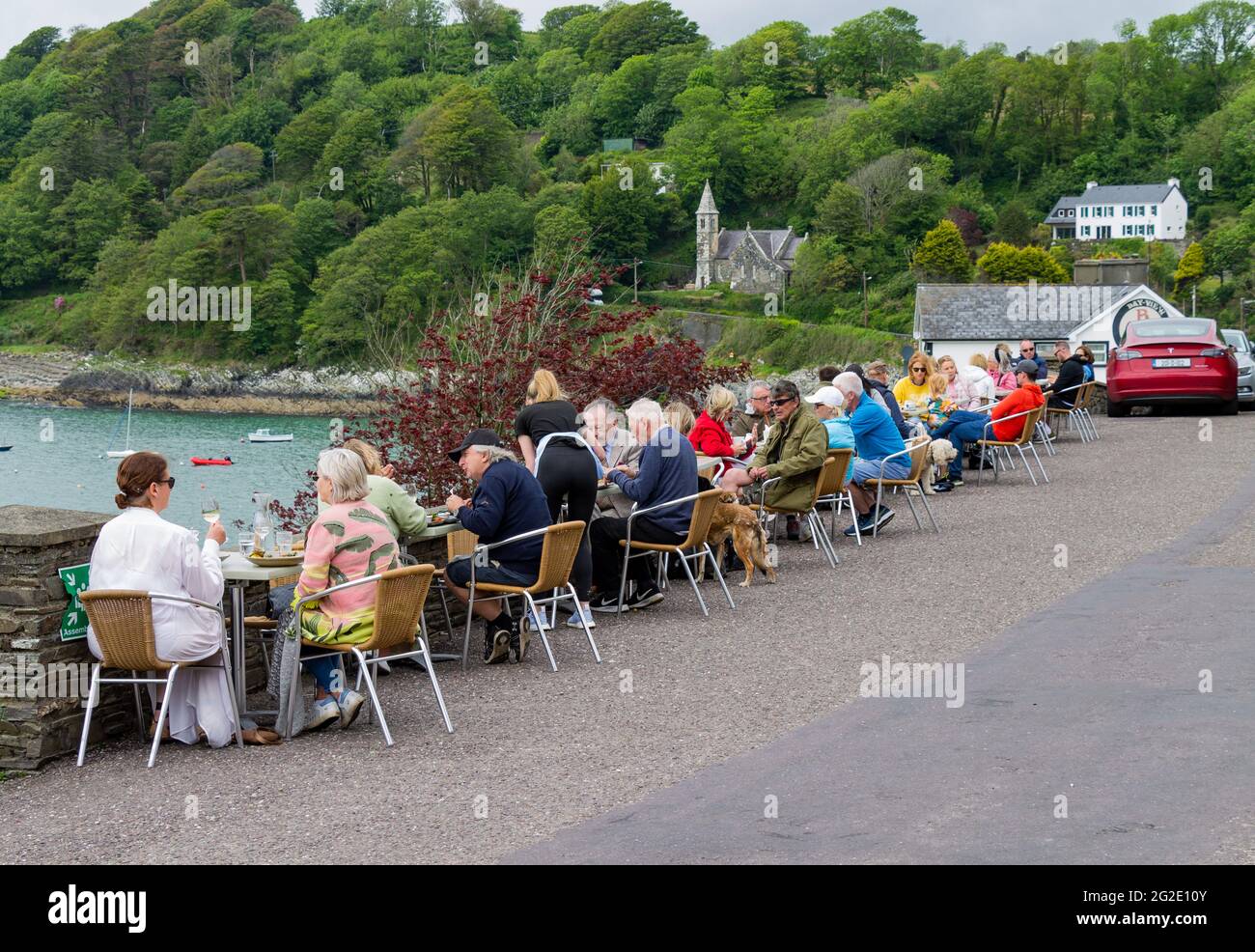 People eating outside restaurant on roadside  due to Covid Pandemic. Glandore, West Cork, Ireland. Stock Photo