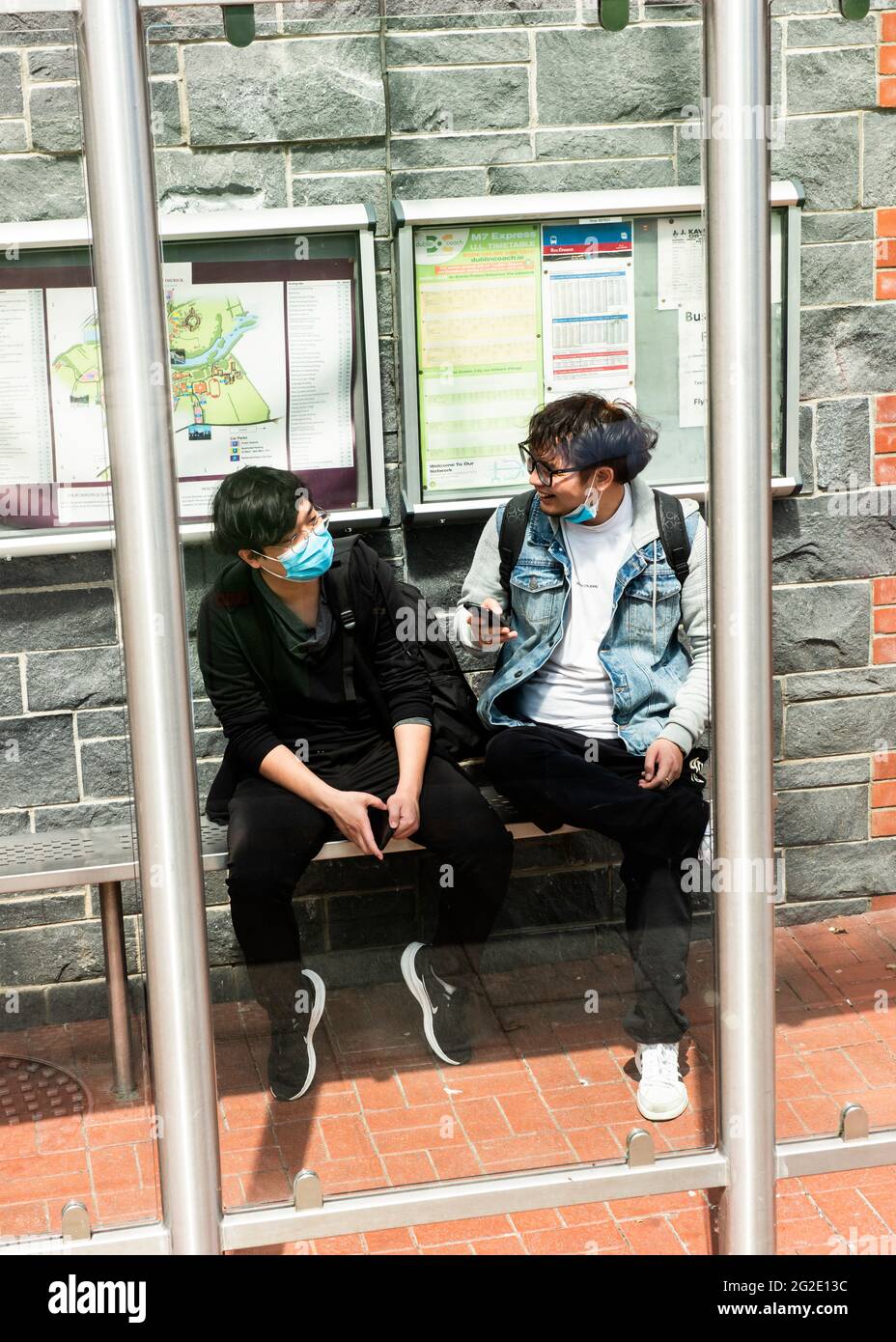 Asian students wearing protective face masks having fun chatting while