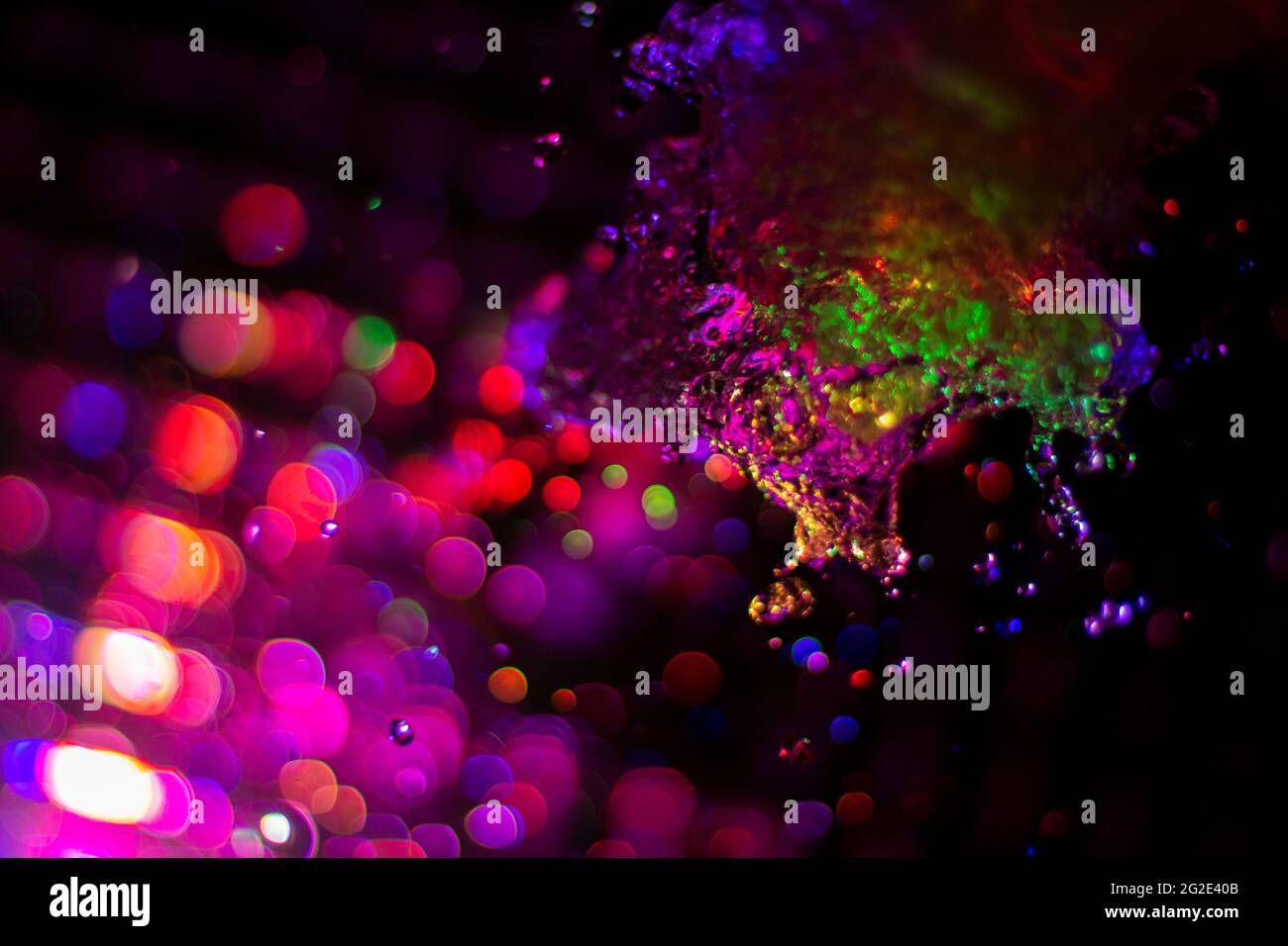 Colored water texture. Splashes of water lit in different colors. Close ...