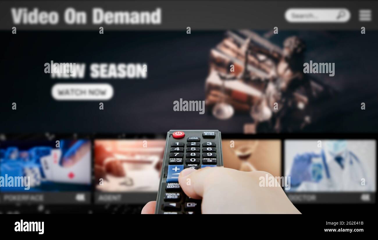 Video on demand, TV streaming, multimedia. Hand holding remote control Stock Photo