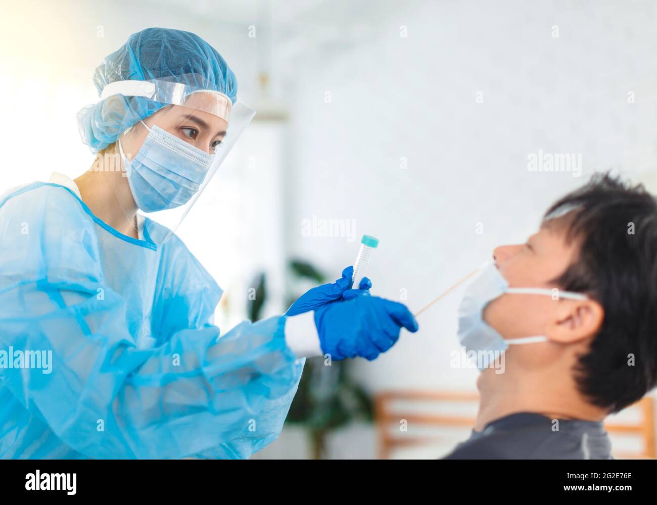 Nurse or doctor wearing gowns, masks, eye shields, do personal protection, is taking swabs for patients Stock Photo