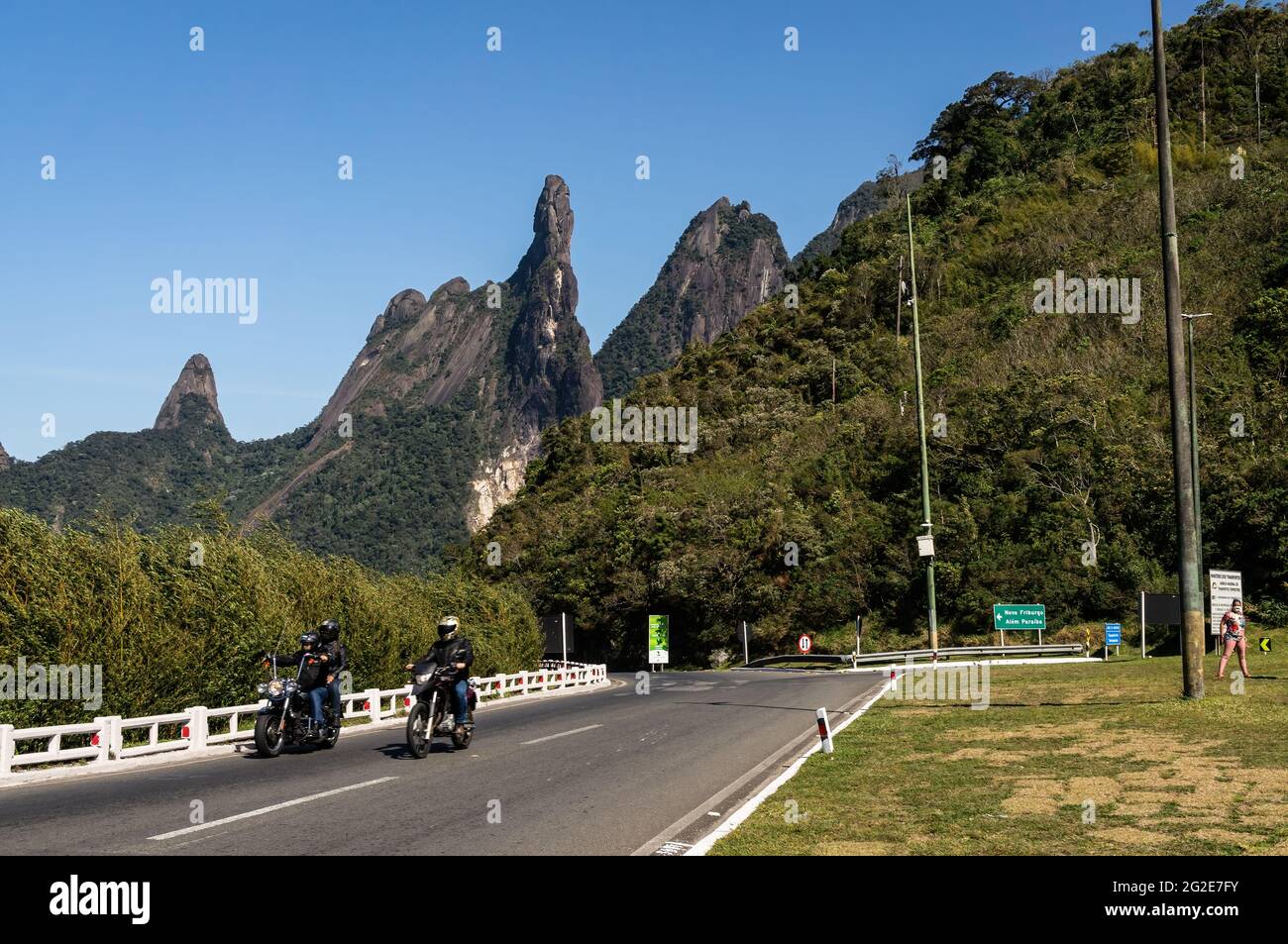 Traffic passing at the cloverleaf interchange of Rio-Teresopolis highway with Our Lady finger, God's Finger and Cabeca de Peixe peaks at the back. Stock Photo