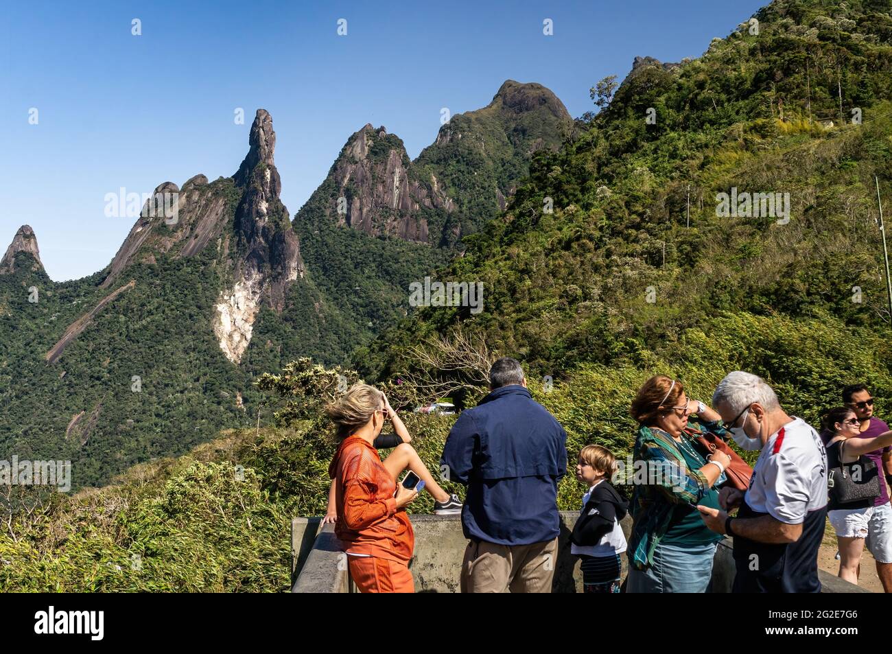 Tourists at Soberbo viewing spot contemplating the view of Our Lady finger, God's Finger and Cabeca de Peixe (Fish Head) peaks in a clear sunny day. Stock Photo
