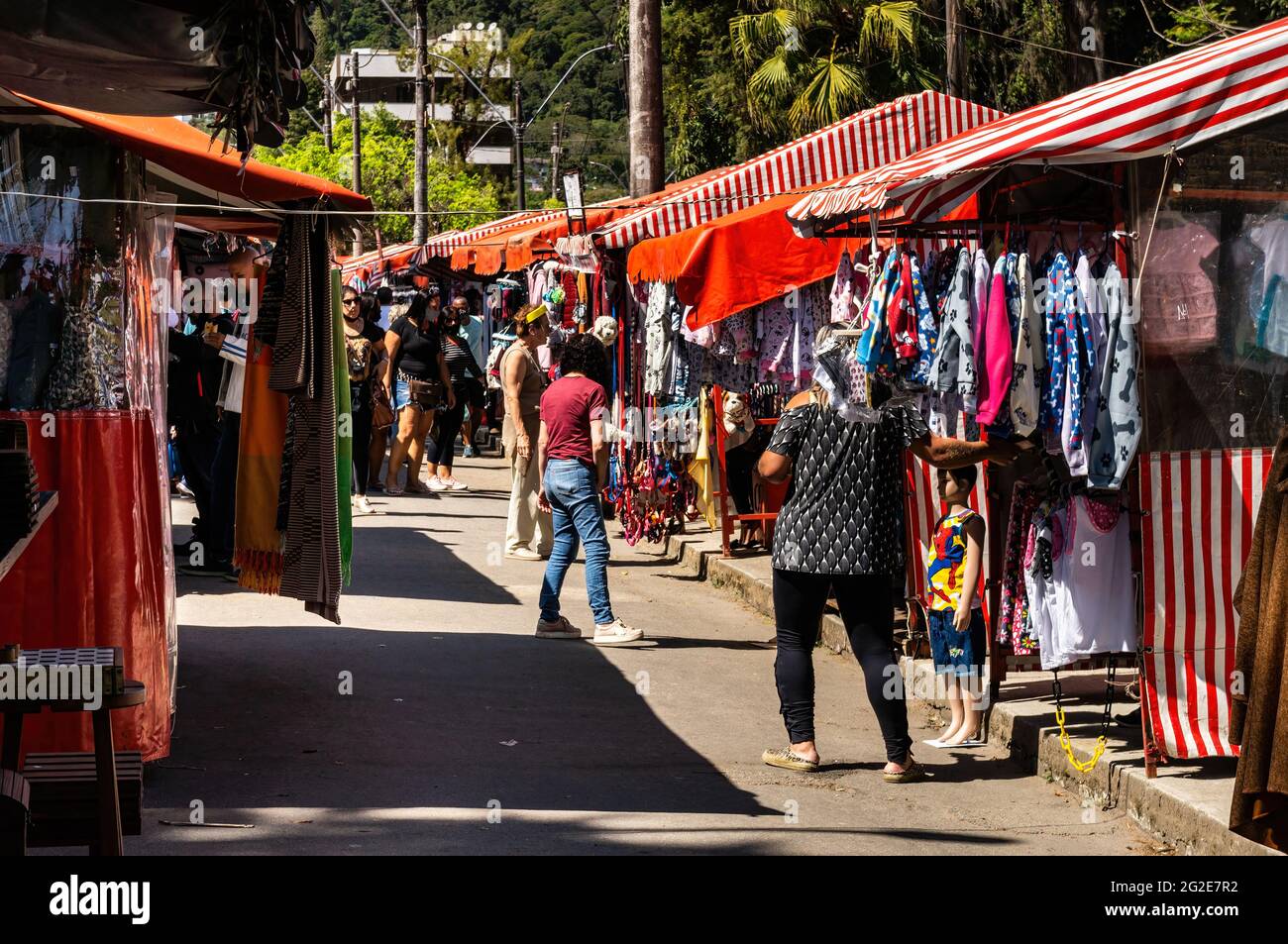 People walking and browsing items for sale in Alto Fair, a public market located in the surroundings of Higino da Silveira square, Alto district. Stock Photo