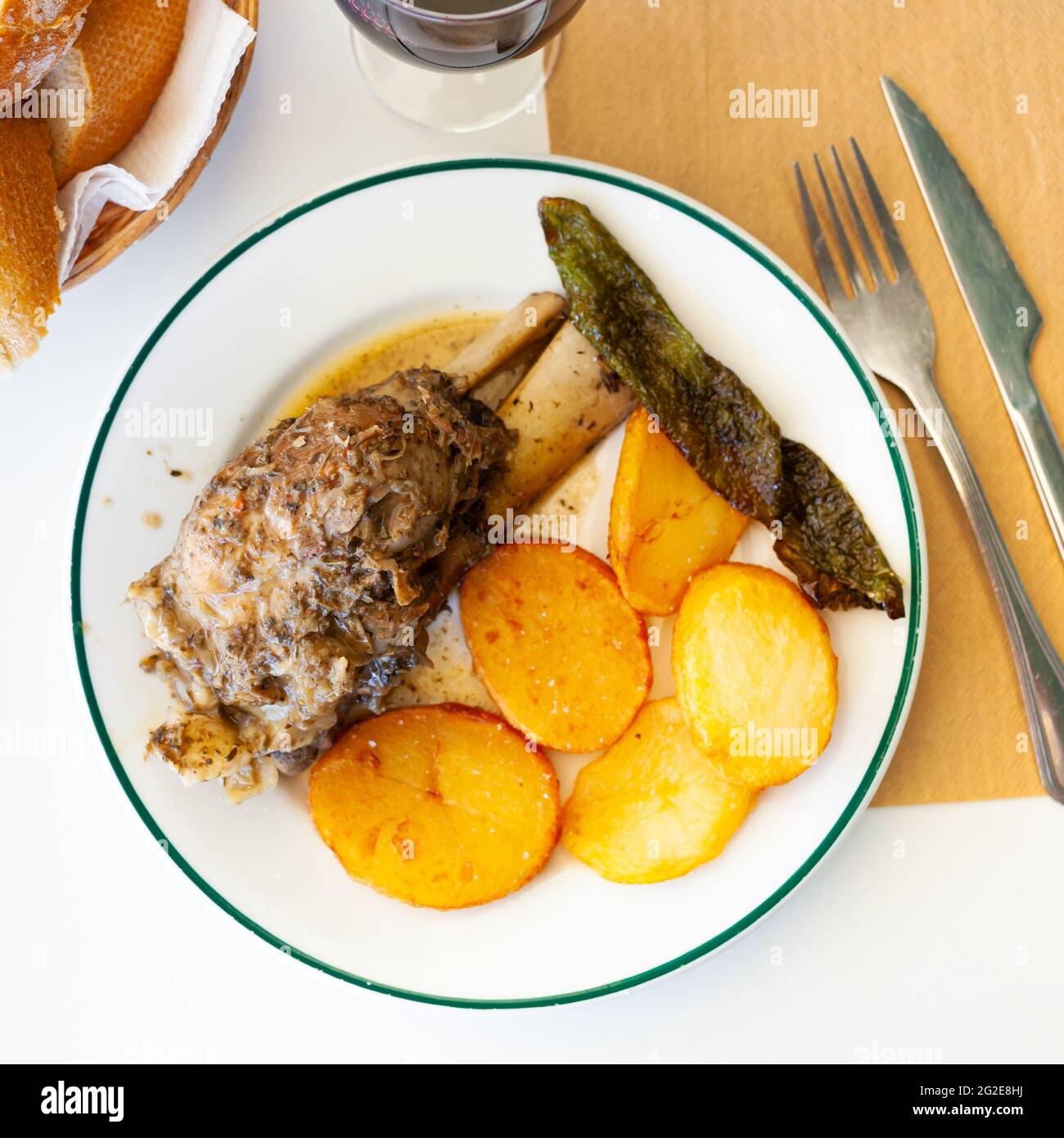 Braised pork knuckle with fried potatoes and baked pepper Stock Photo