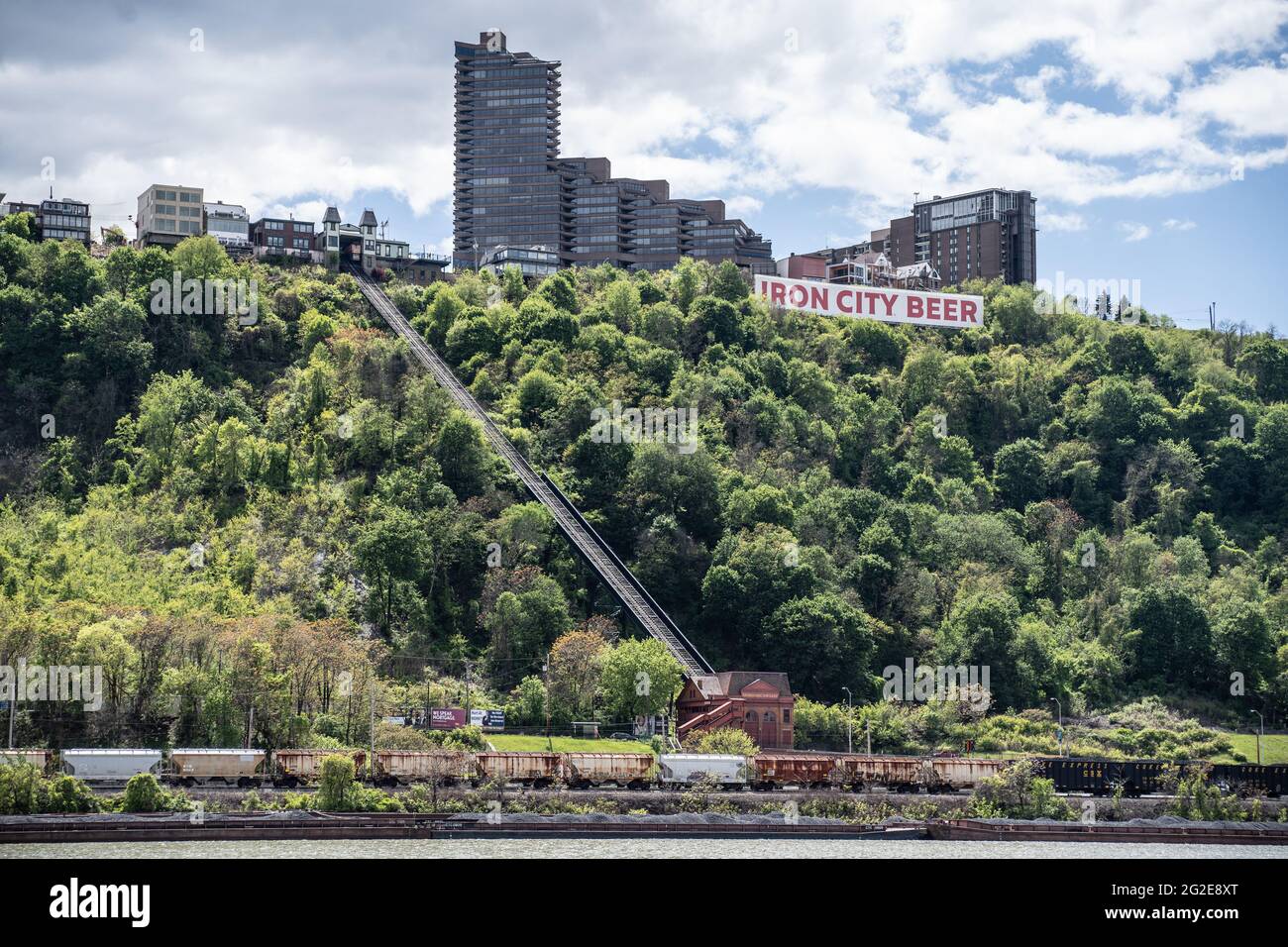 Pittsburgh, Pennsylvnia, USA- May 12, 2021: Train passes infront of Duquesne Incline and Mount Washington with view from Point State Park Stock Photo