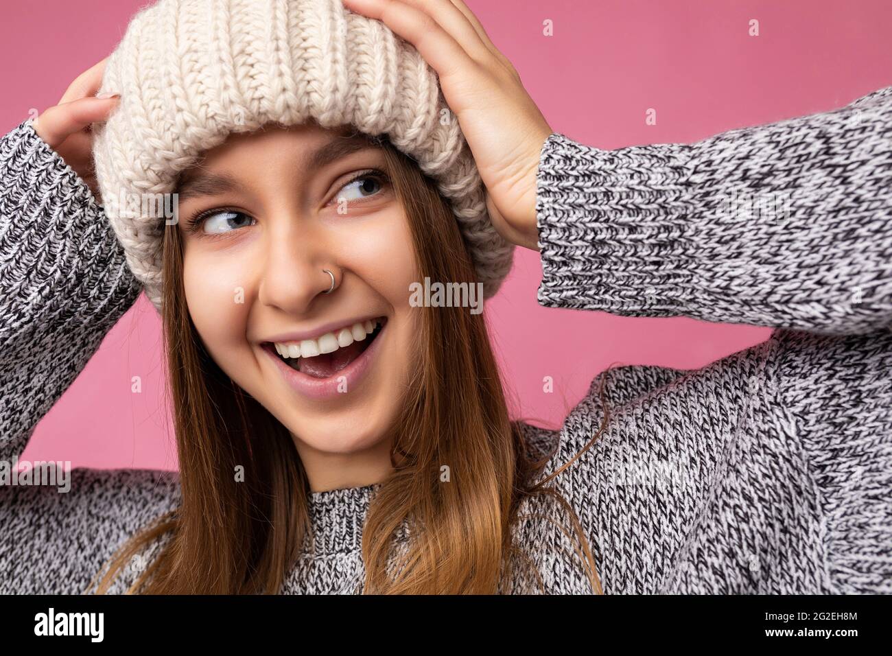 Closeup photo of beautiful happy surprised young dark blonde woman standing isolated over colourful background wall wearing everyday trendy clothes Stock Photo
