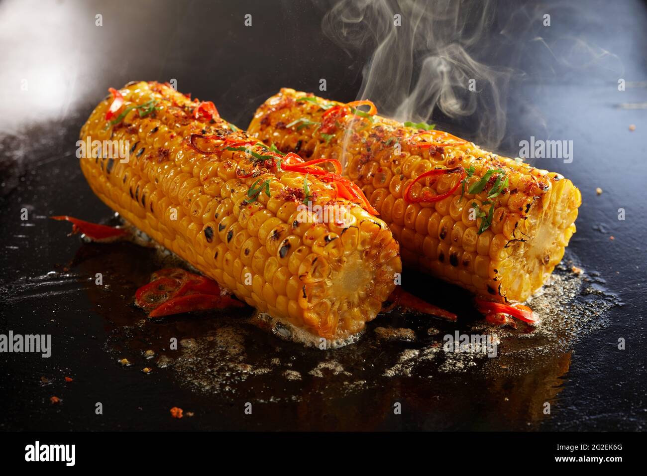 High angle of delicious corn cobs preparing in oil on hot surface in kitchen Stock Photo