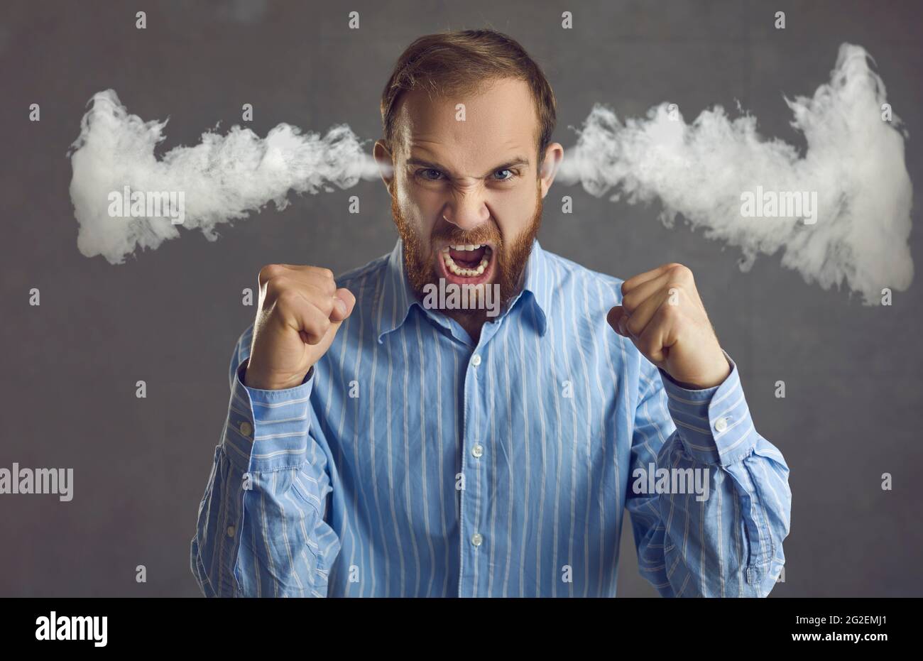 Angry business man shouting with steam coming out of ears isolated on grey background Stock Photo