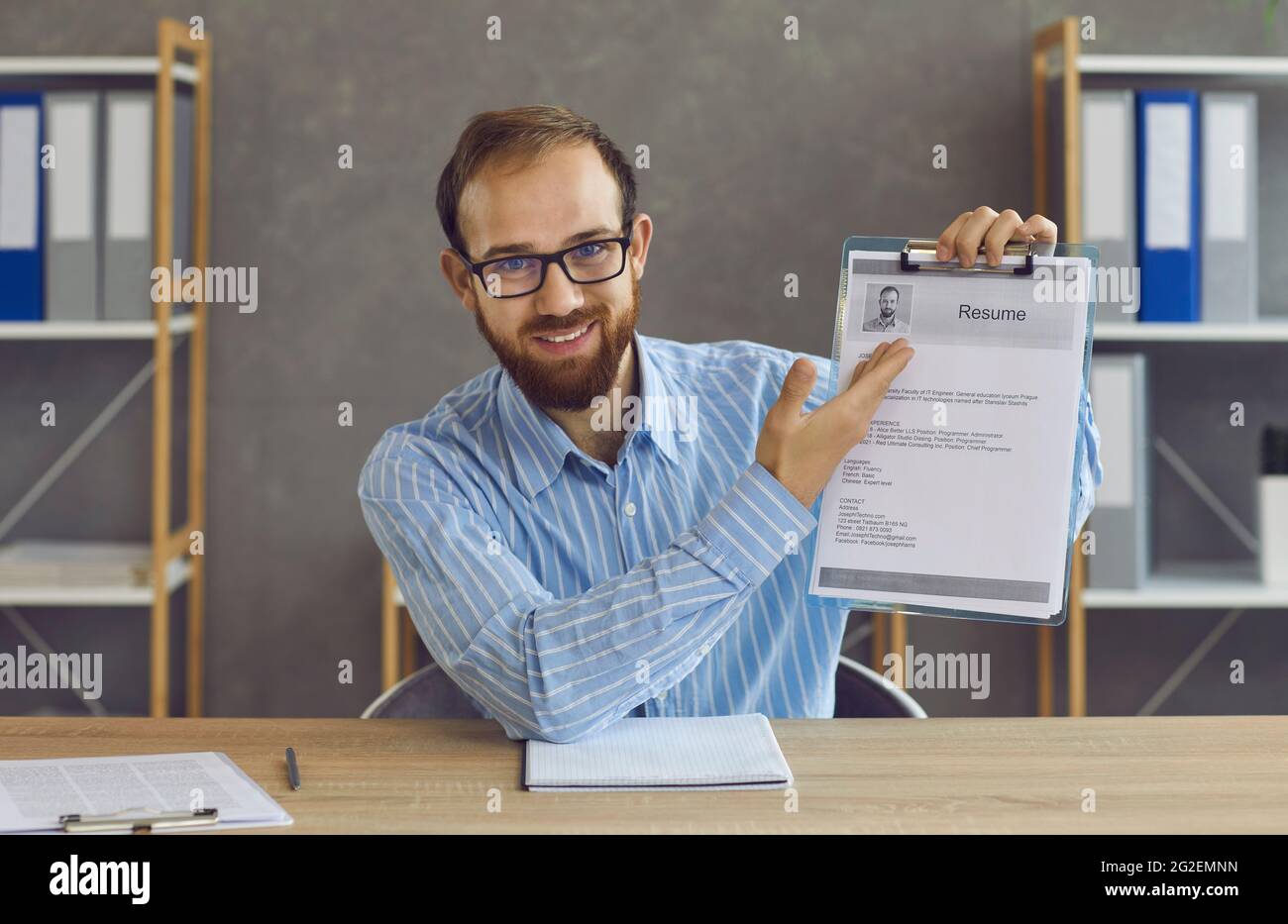 Unemployed man or professional career advisor shows a printed version of a resume Stock Photo