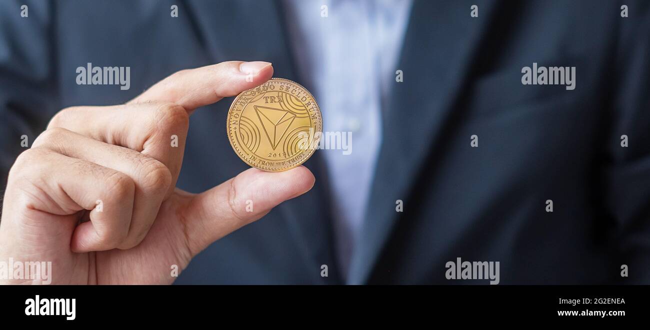 man hand holding gold Tron coin (TRX) cryptocurrency, Crypto is Digital  Money within the blockchain network, is exchanged using technology and  online Stock Photo - Alamy