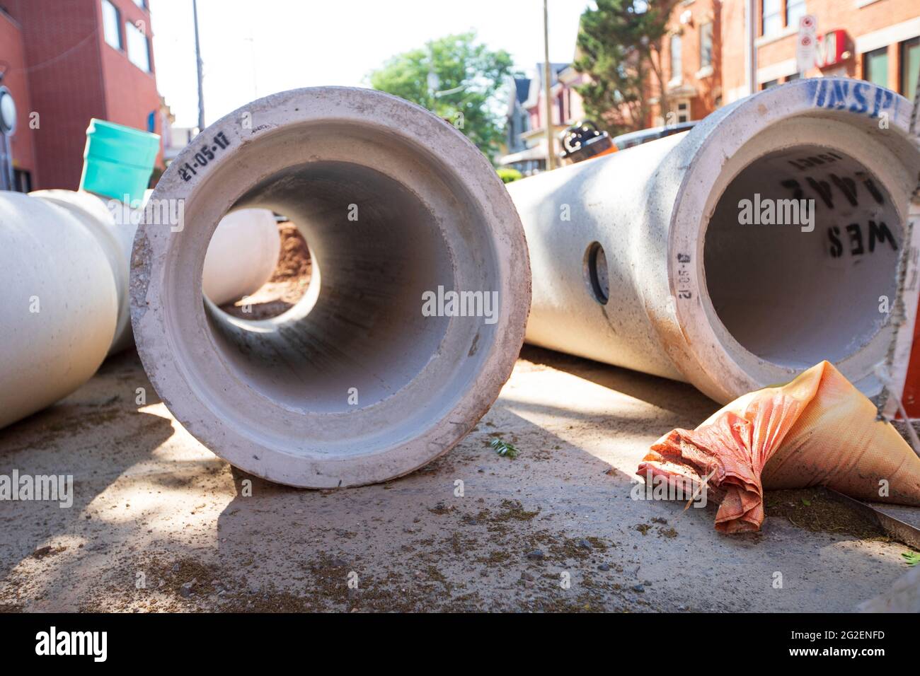 New concrete sewer pipes are laying on the road to be installed at Mulberry street in a downtown Hamilton major construction project. Stock Photo