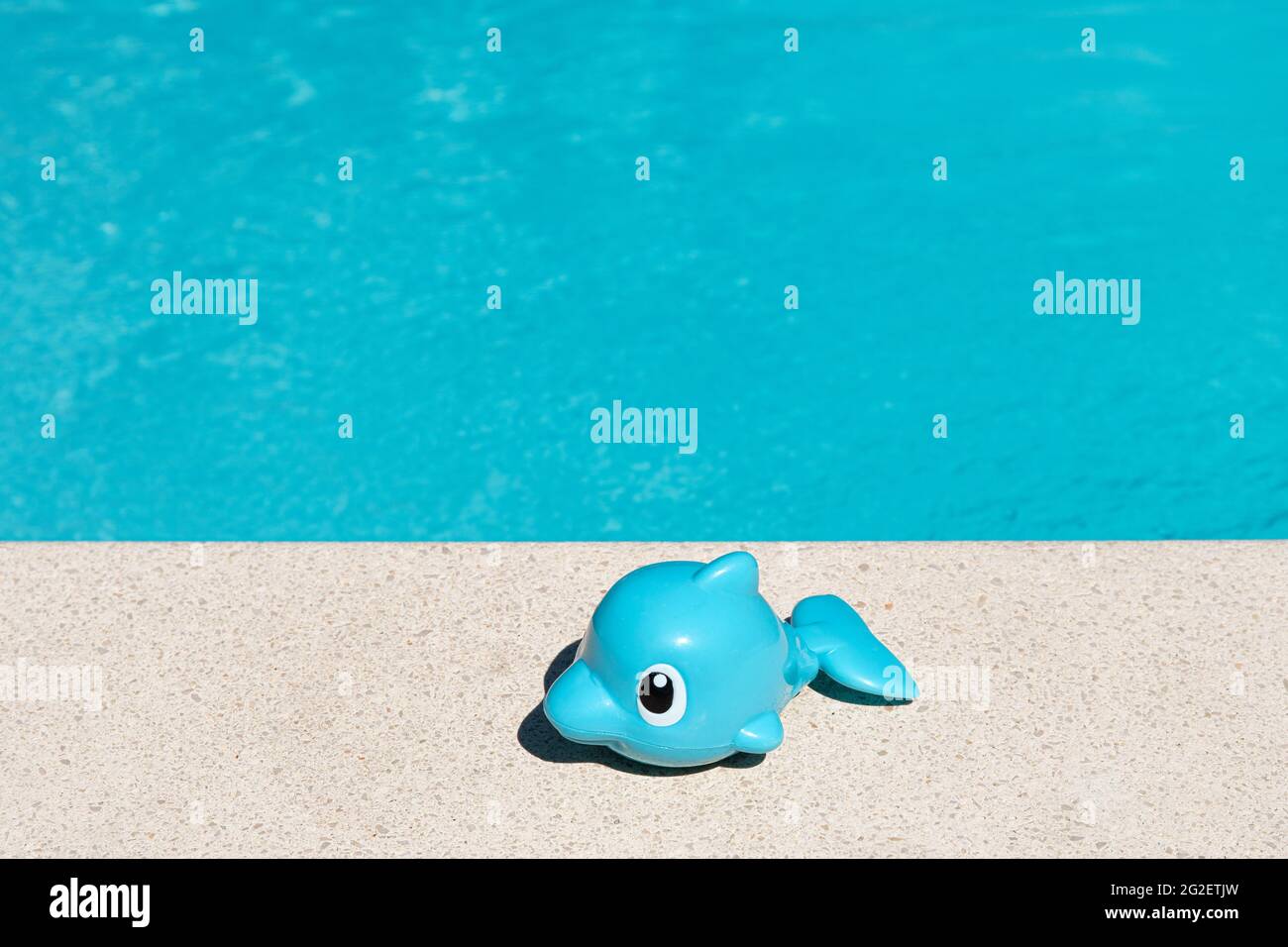 Cute Toy Fish on swimming pool border. Summertime enjoyment concept background. Copy space Stock Photo