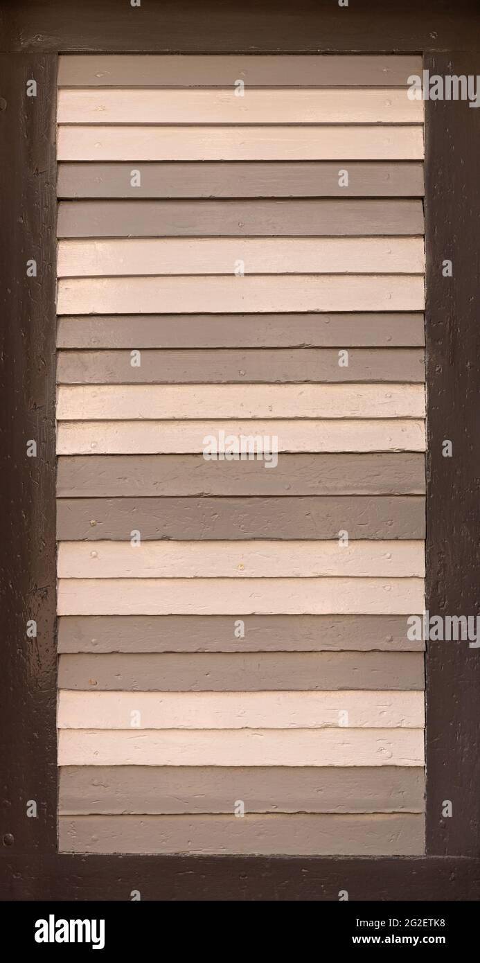 Old shutter with slats, painted in different shades of brown Stock Photo