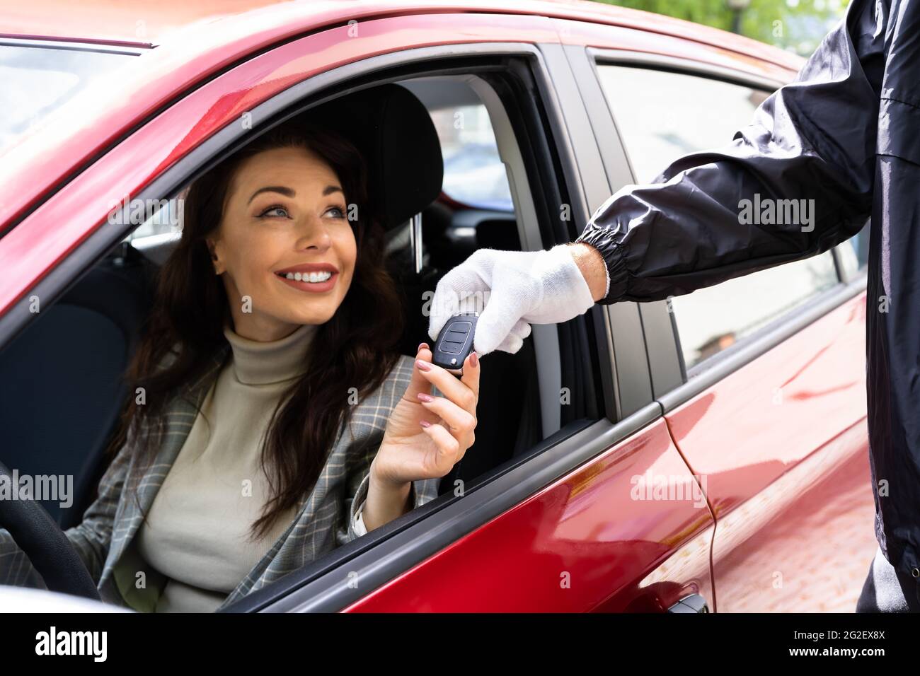 Valet Parking Giving Car Key To Young Woman Stock Photo