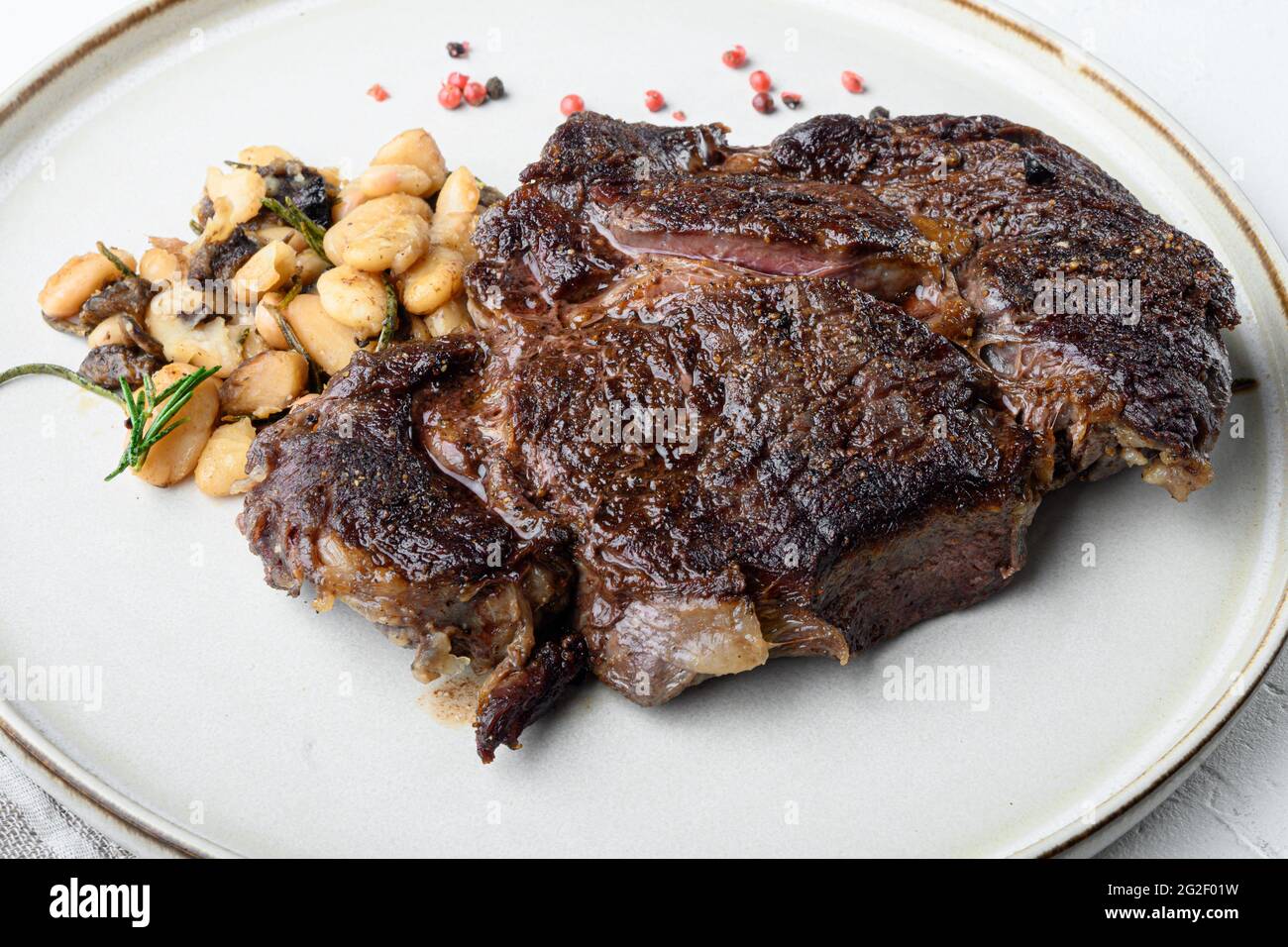 Legendary grilled rib eye with beans set, on white stone surface Stock ...