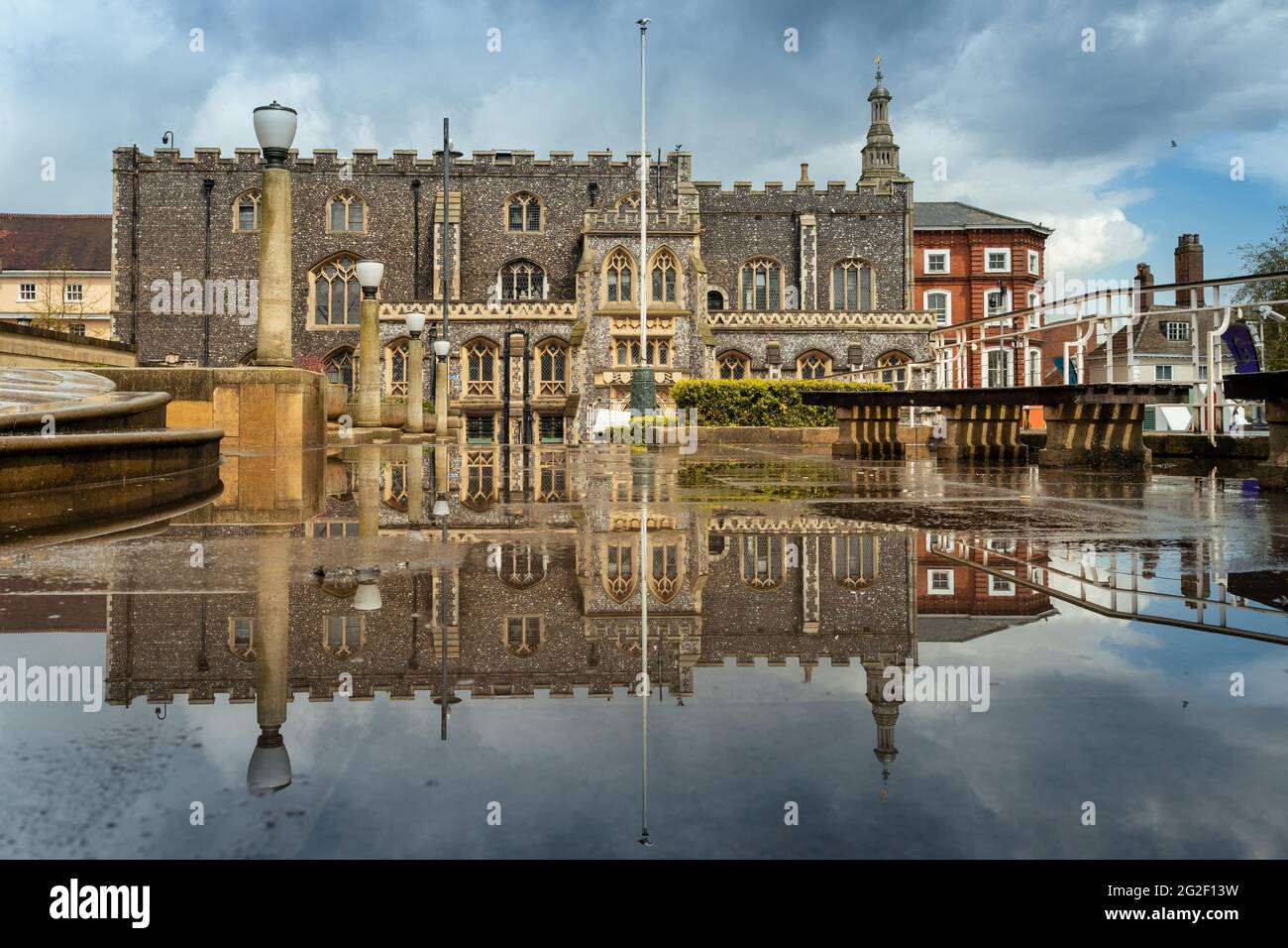 Norwich guildhall reflecting in rain water puddle Stock Photo