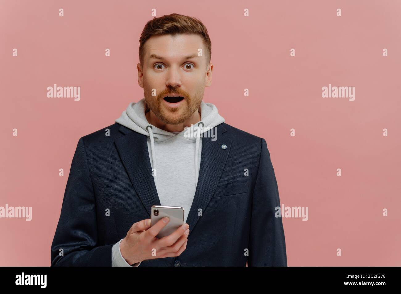Impressed man reading latest news with surprised face expression Stock