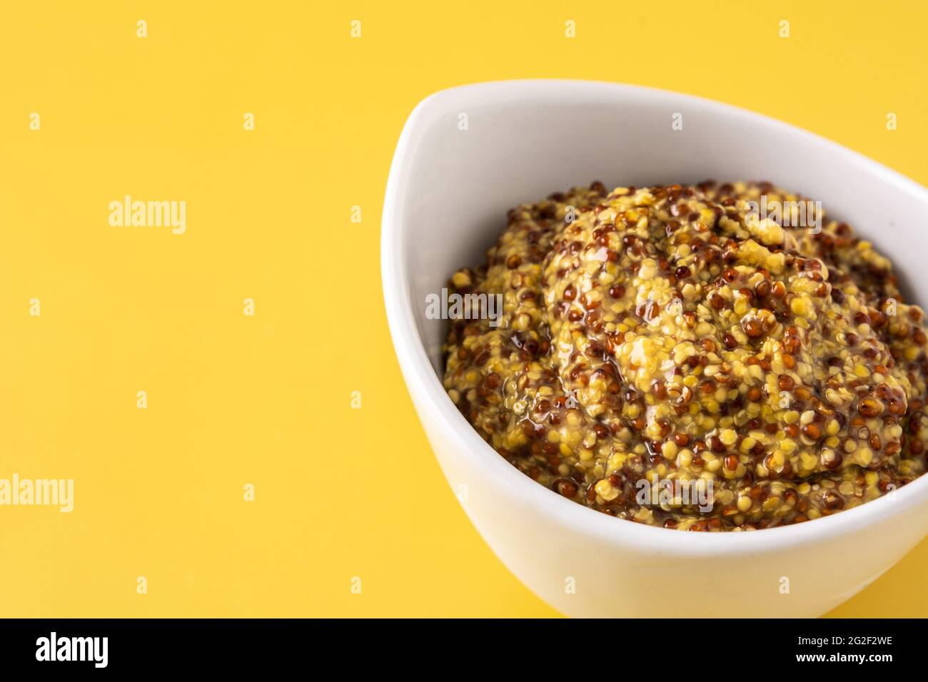Mustard sauce in white bowl and yellow background Stock Photo - Alamy