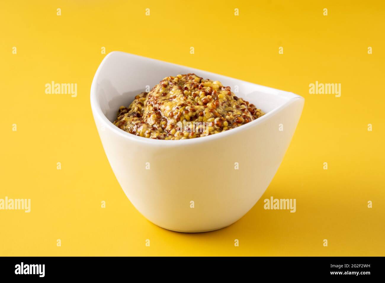 Mustard sauce in white bowl and yellow background Stock Photo - Alamy