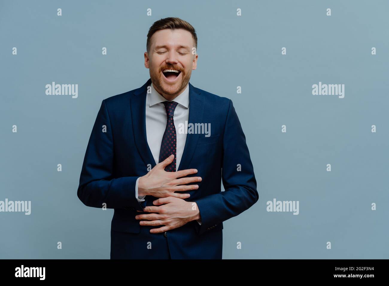 Overjoyed businessman in suit laughing out loud and having fun Stock Photo