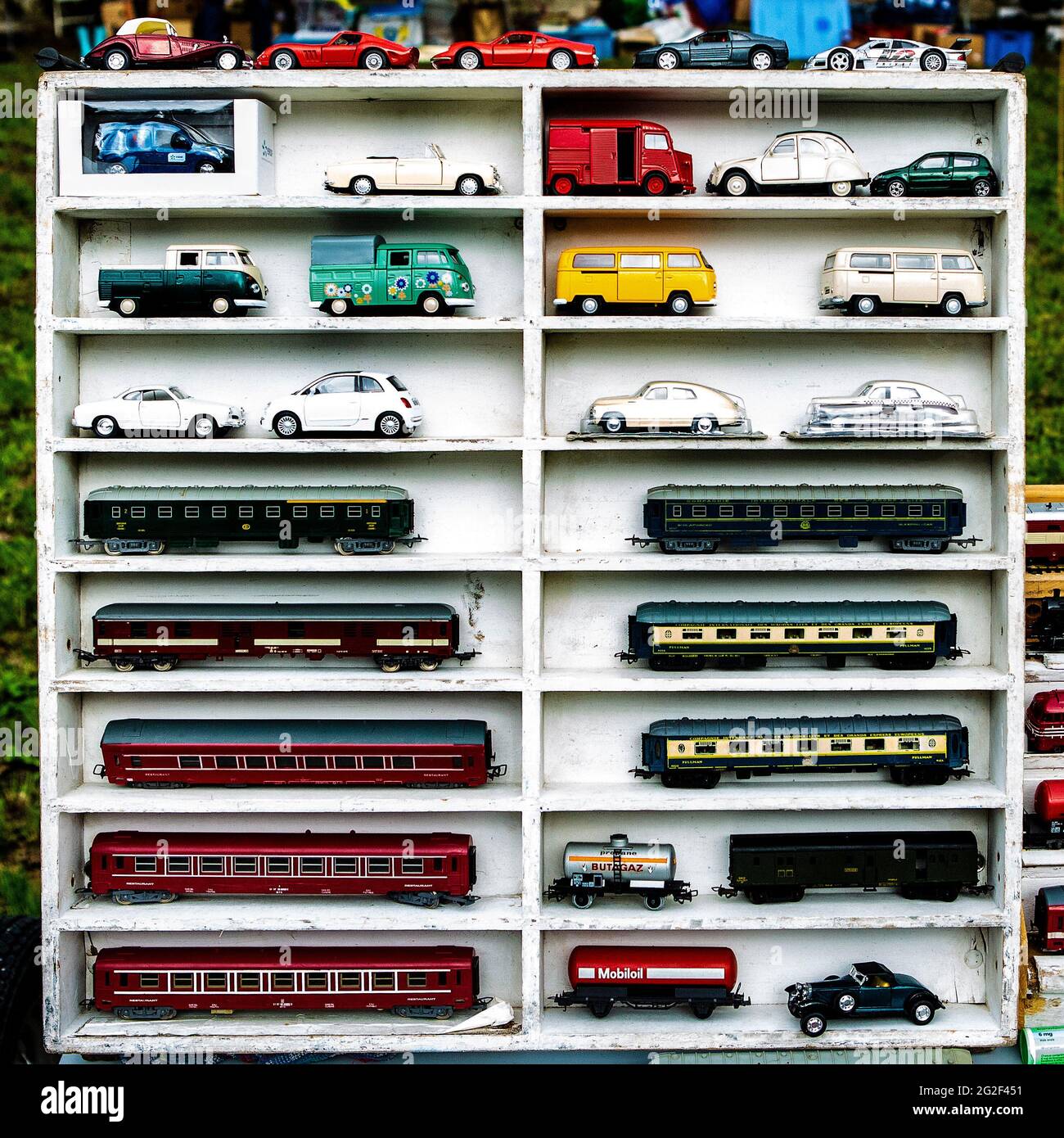 Modellautos in einem Setzkasten auf dem Flohmarkt. Citroen Hy, VW Busse, Karmann Ghia und andere Oldtimer Stock Photo