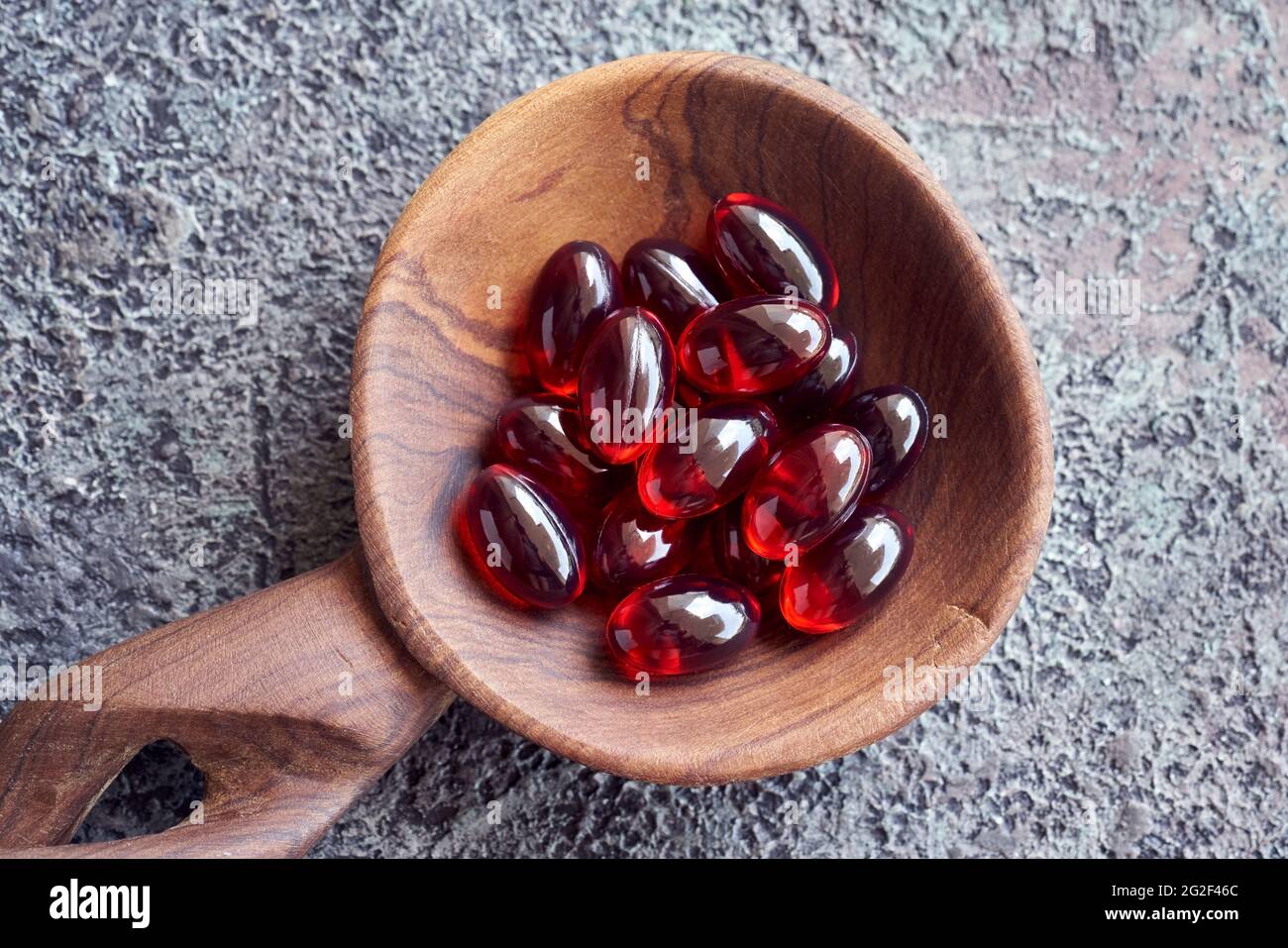 Red krill oil soft gel capsules on a spoon, top view. Healthy
