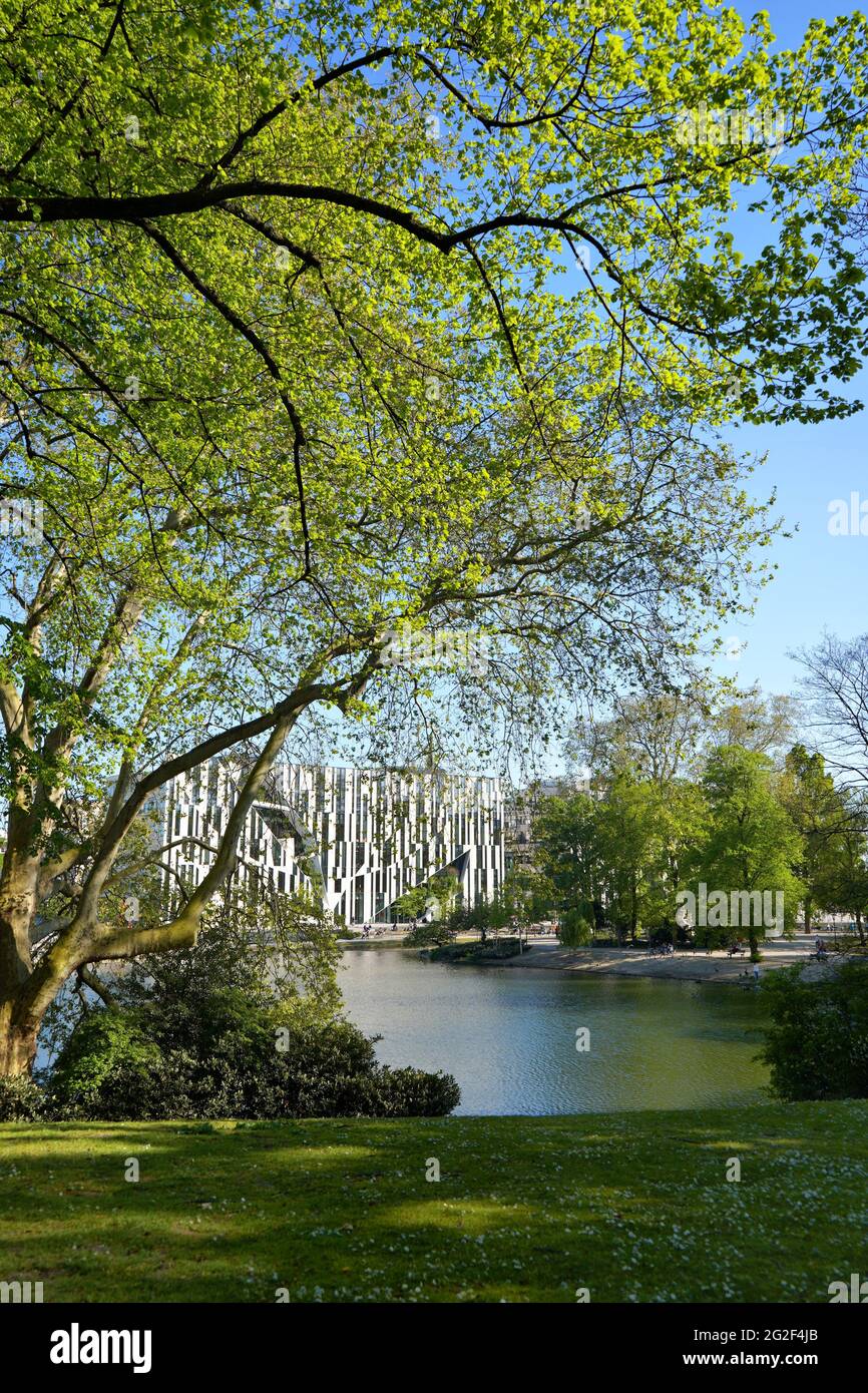 The 'Kö-Bogen', seen through the branches of trees in the public garden 'Hofgarten'. Kö-Bogen has been designed by New York star architect Libeskind. Stock Photo