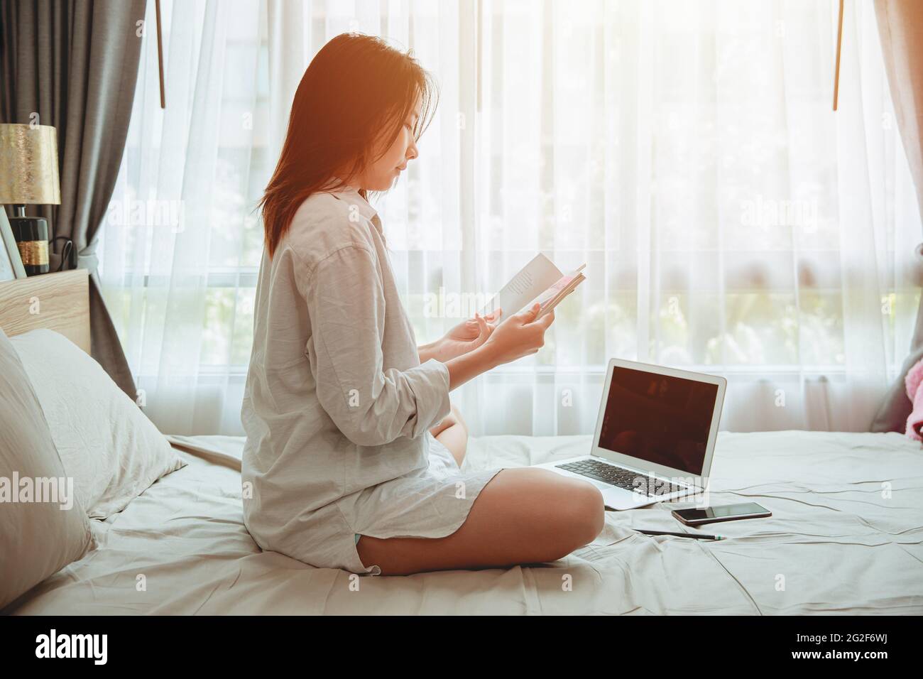 Girl teen read a book self education or working at home during covid self quarantine. women reading a book at bed in the morning. Stock Photo