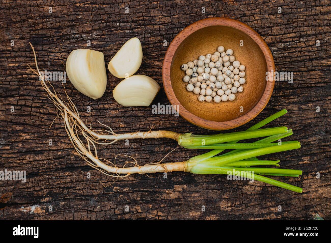 Coriander root Garlic and Pepper seeds or Three kings of Thai food ingredient shot on wooden old