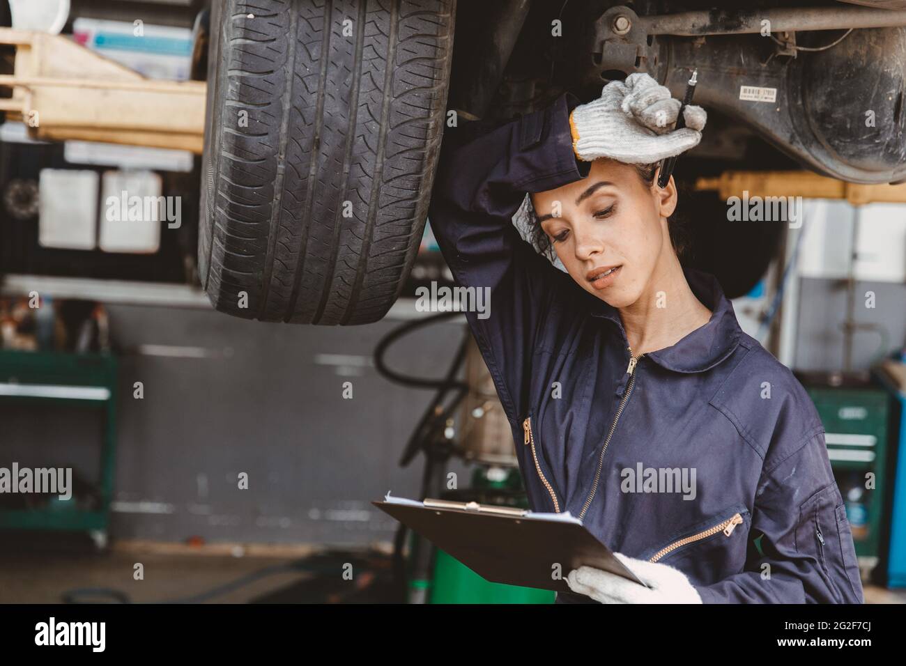 black women worker staff hard working at the garage car checking feel hot and tired uncomfortable Stock Photo