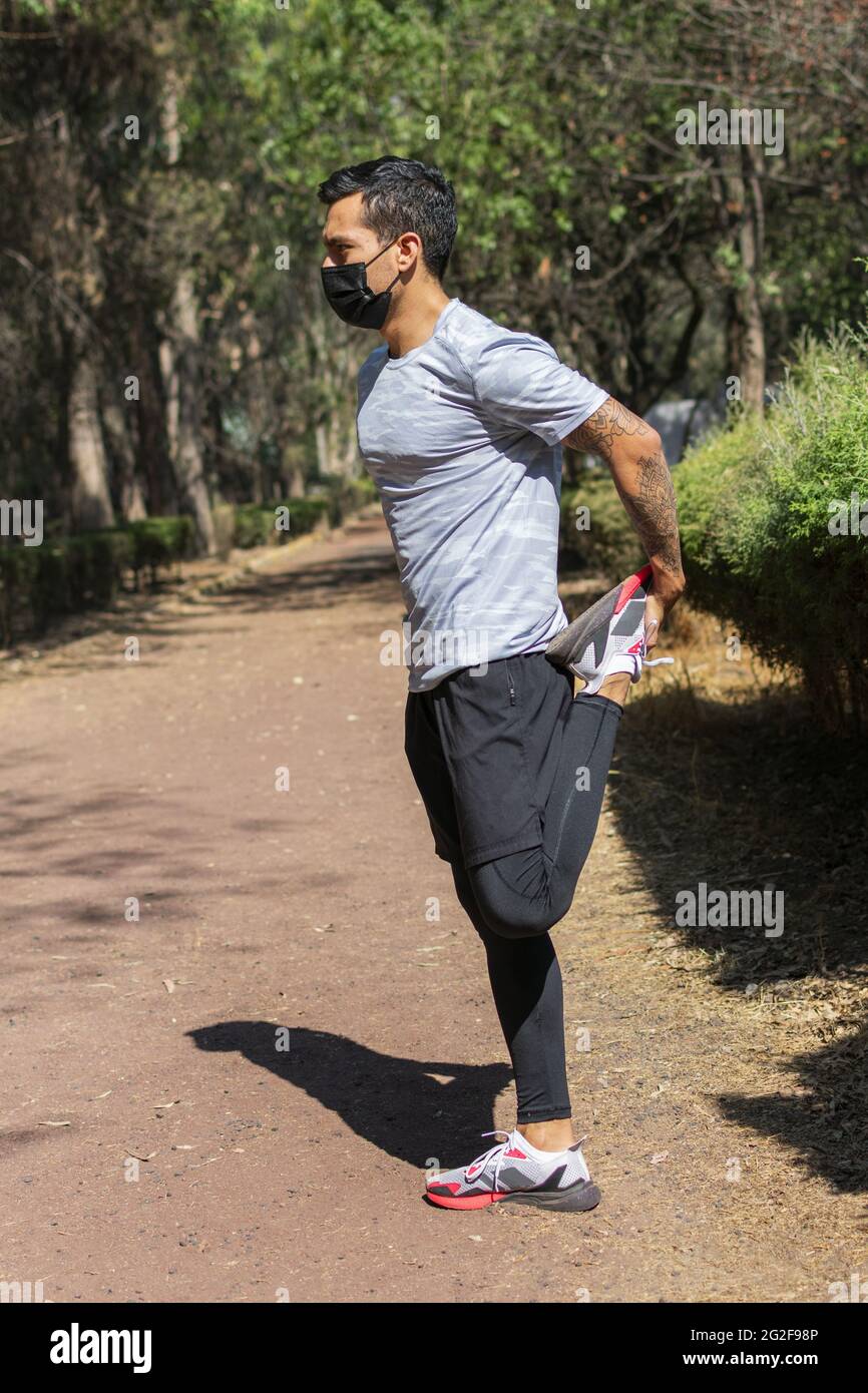 young latin man doing leg stretching exercises before running in the morning Stock Photo Alamy