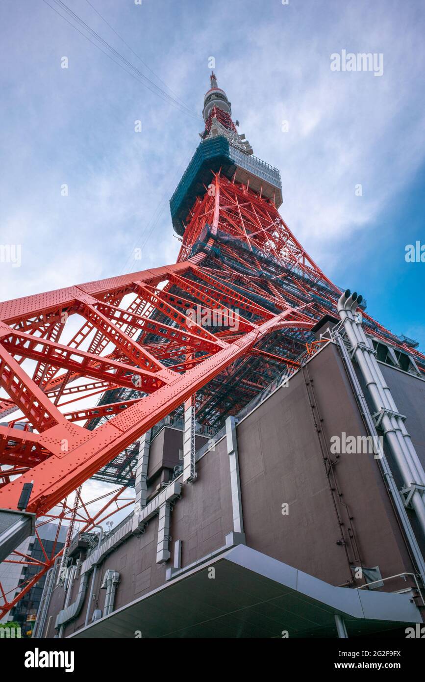 Tokyo, Japan - 12.05.2019: Vertical wide angle shot of red steel construction of Tokyo Tower from below with blue sky in the background Stock Photo
