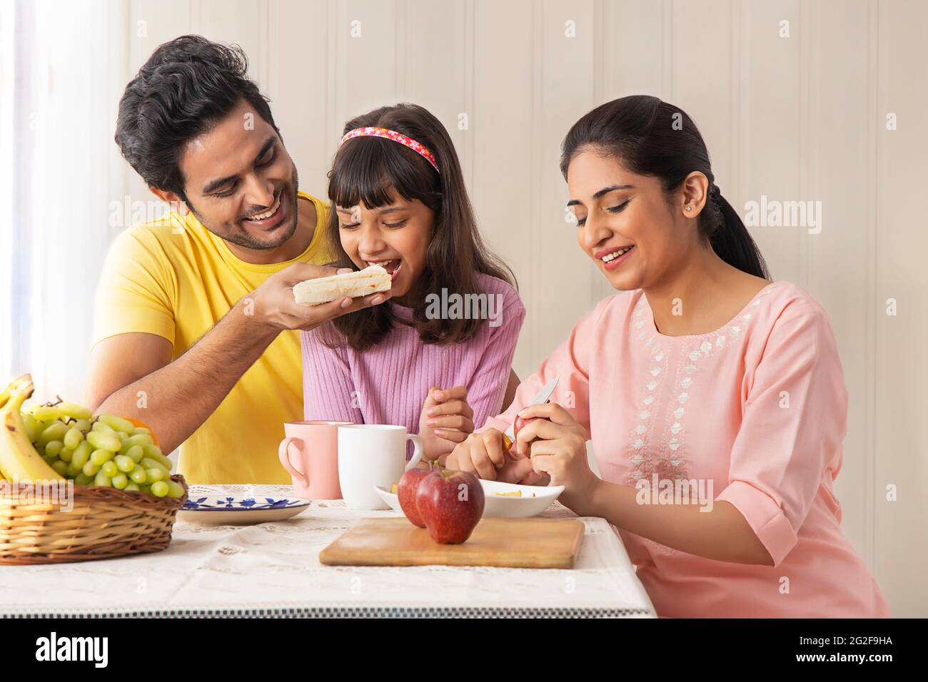 A HAPPY FAMILY SITTING TOGETHER AND HAVING BREAKFAST Stock Photo - Alamy