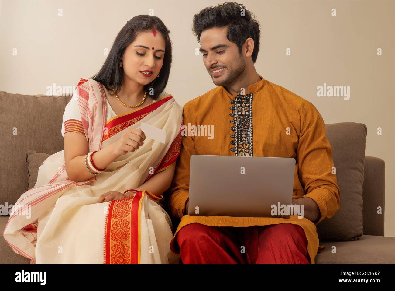 A HAPPY COUPLE IN TRADITIONAL CLOTHING LOOKING AT EACH OTHER WHILE ...