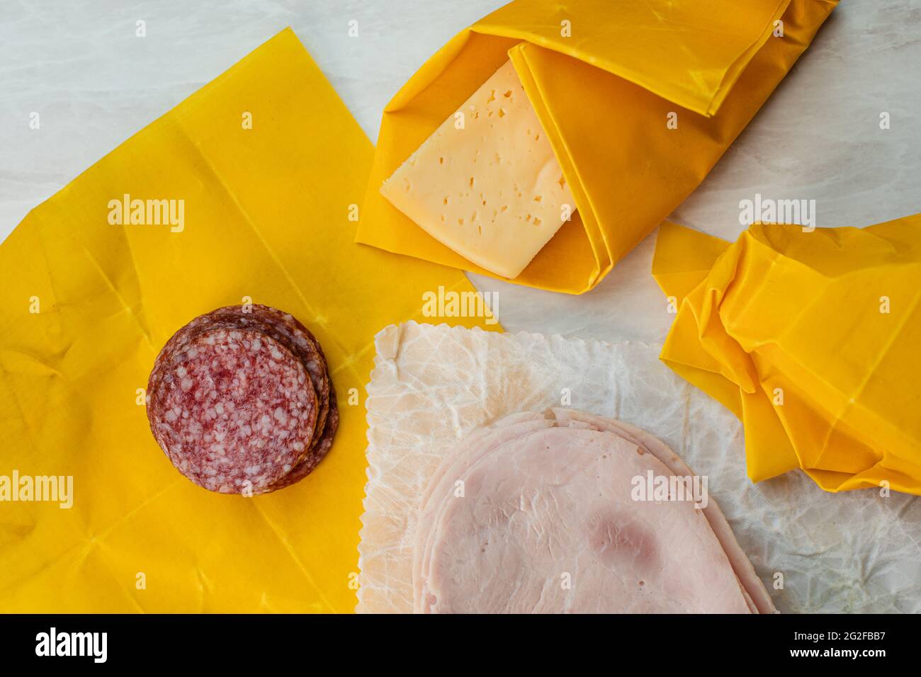 Cheese, salami and ham slices wrapped into beeswax paper Stock Photo