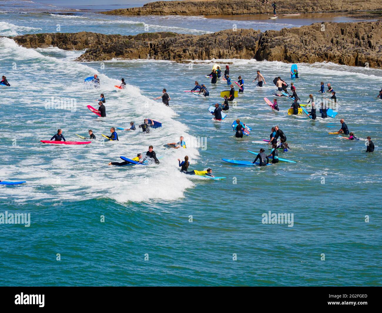 Lots of people bodyboarding in the sea, Bude, Cornwall, UK Stock Photo