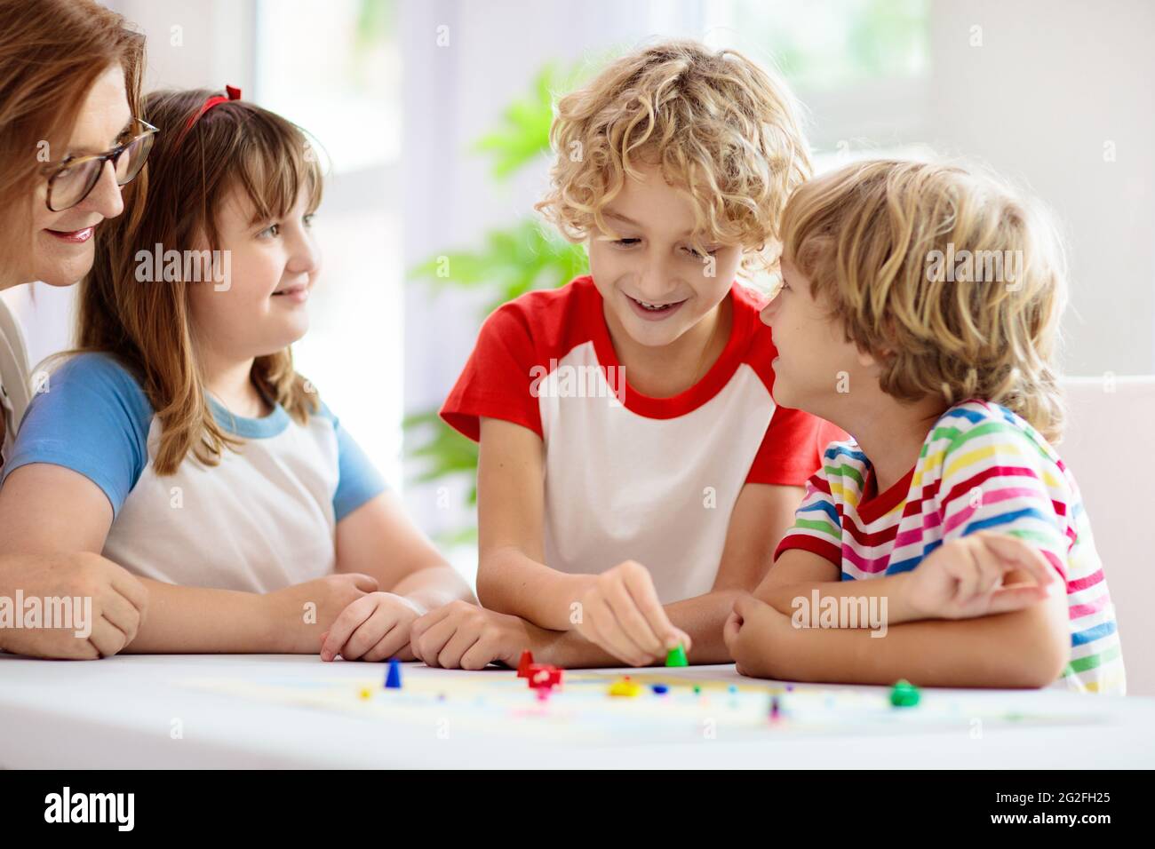 Family playing board game at home. Kids play strategic game. Little boy